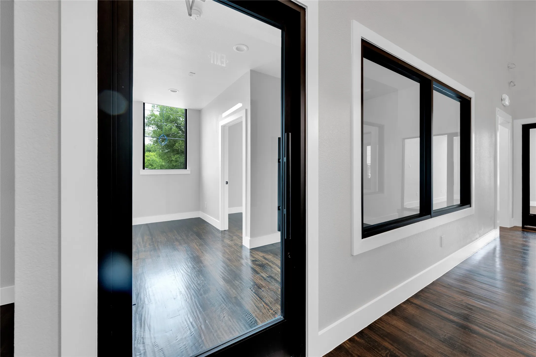 Hallway featuring wood-finish flooring, light gray walls, white trim, and recessed lighting