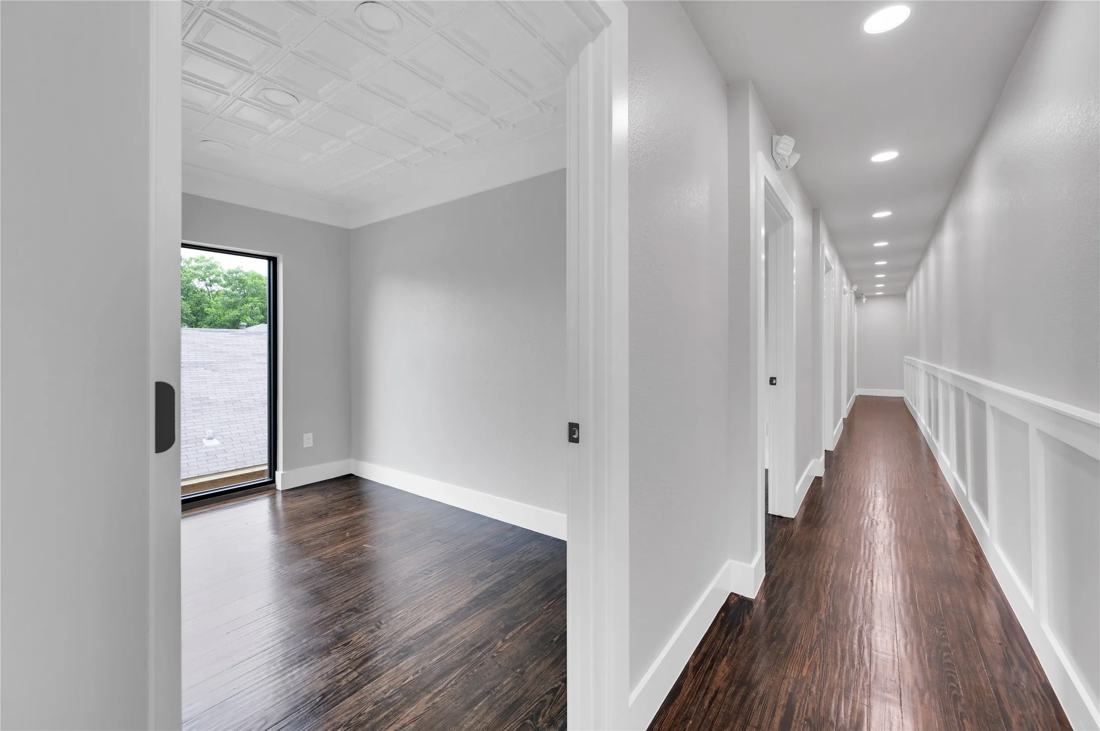 Hallway featuring recessed lighting, a board and batten wall treatment, and dark wood-finish flooring