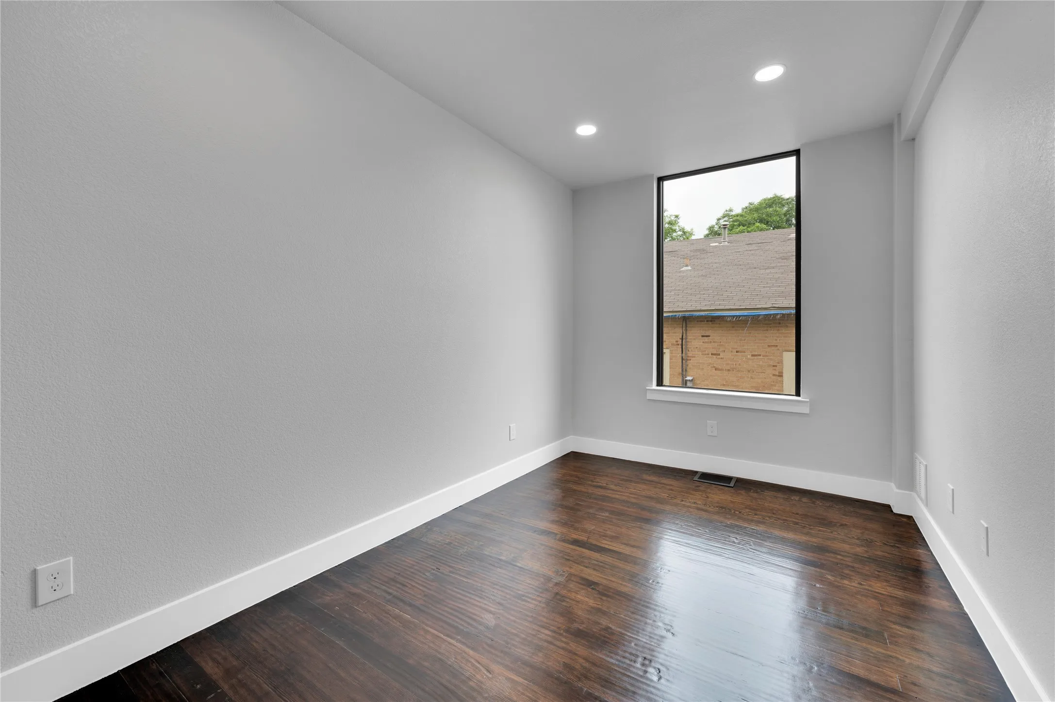 Bedroom featuring a tall, rectangular window with a black frame