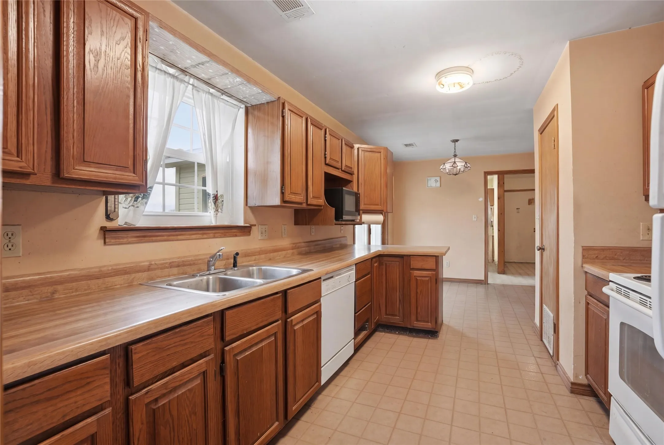 This kitchen blends warm wood tones with a smart layout, delivering both comfort and everyday functionality