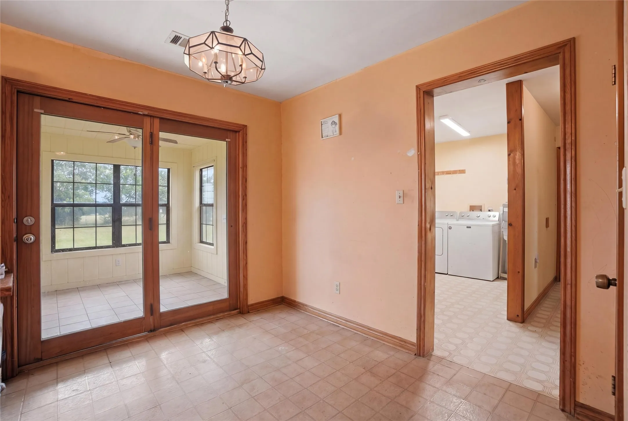 Bright dining nook with an open, connected layout that leads to a sunroom and laundry for added convenience