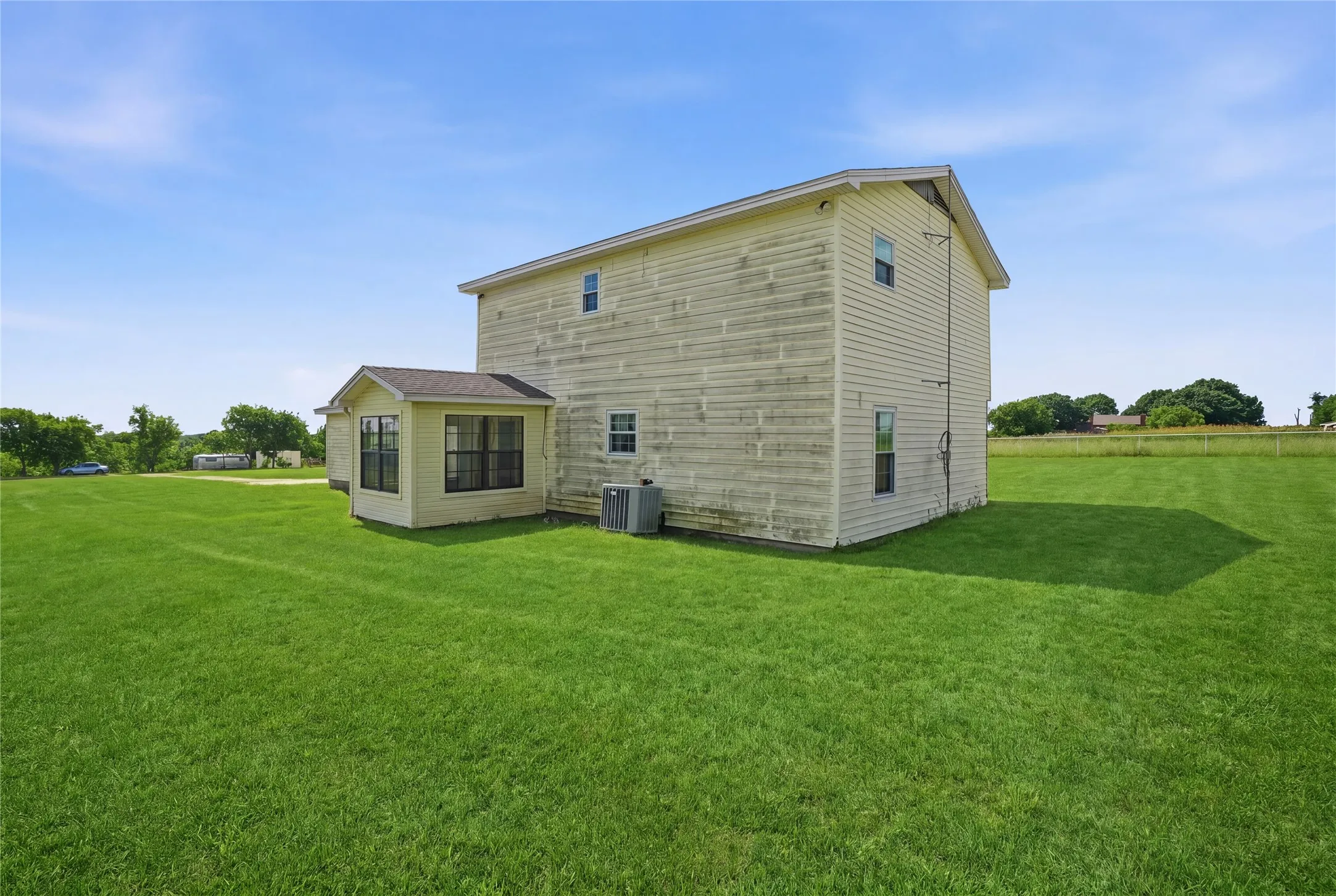 Rear view of home with large open yard space