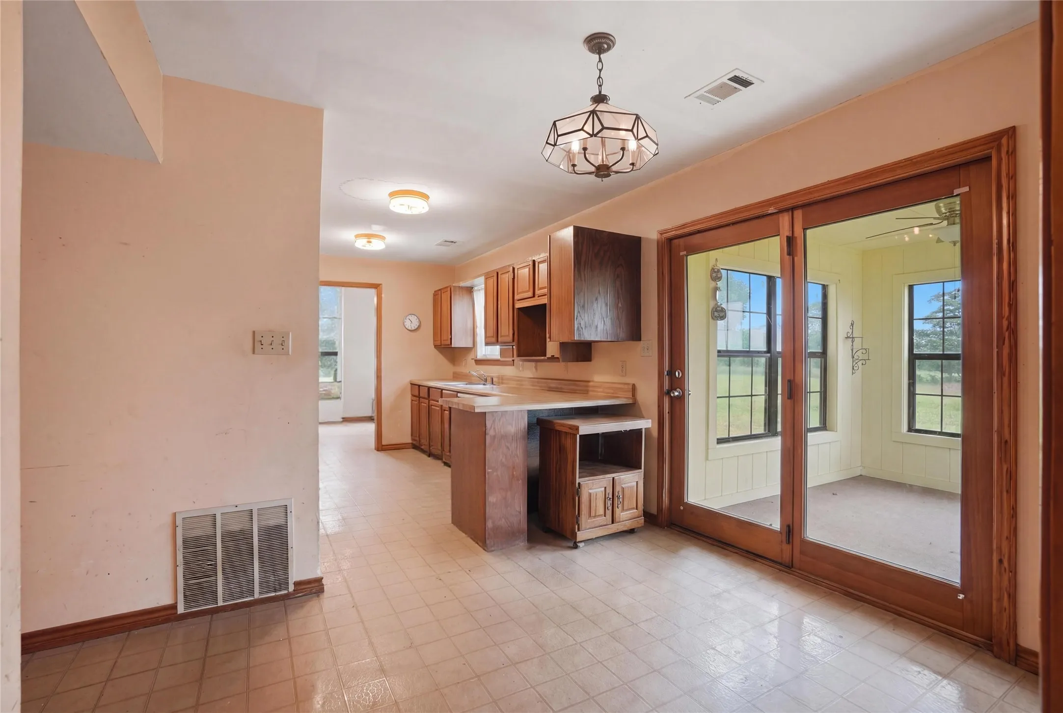 Bright and functional kitchen featuring sliding glass doors that lead to a sunroom filled with natural light