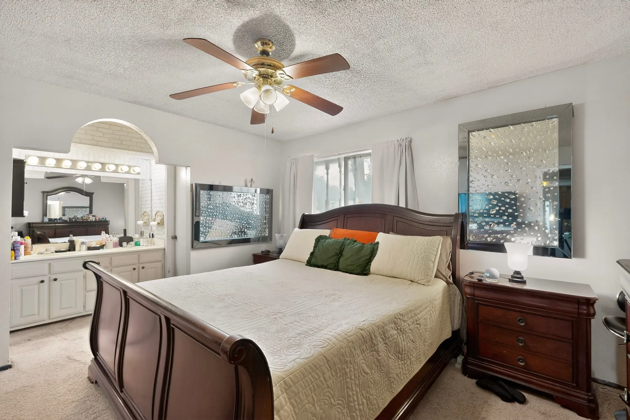Bedroom featuring a ceiling fan, a window with curtains, and carpeting