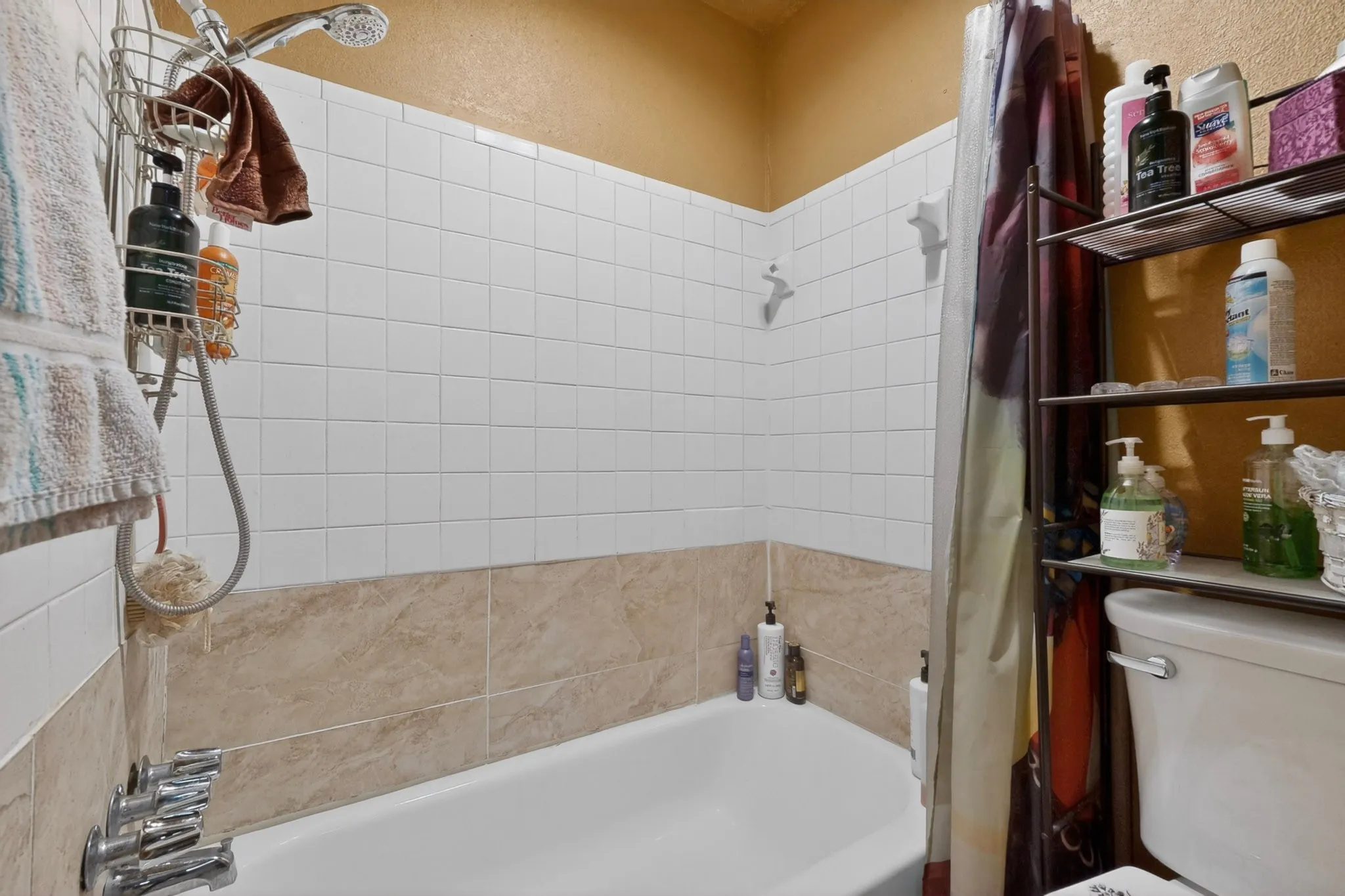 White porcelain bathtub with chrome fixtures and showerhead