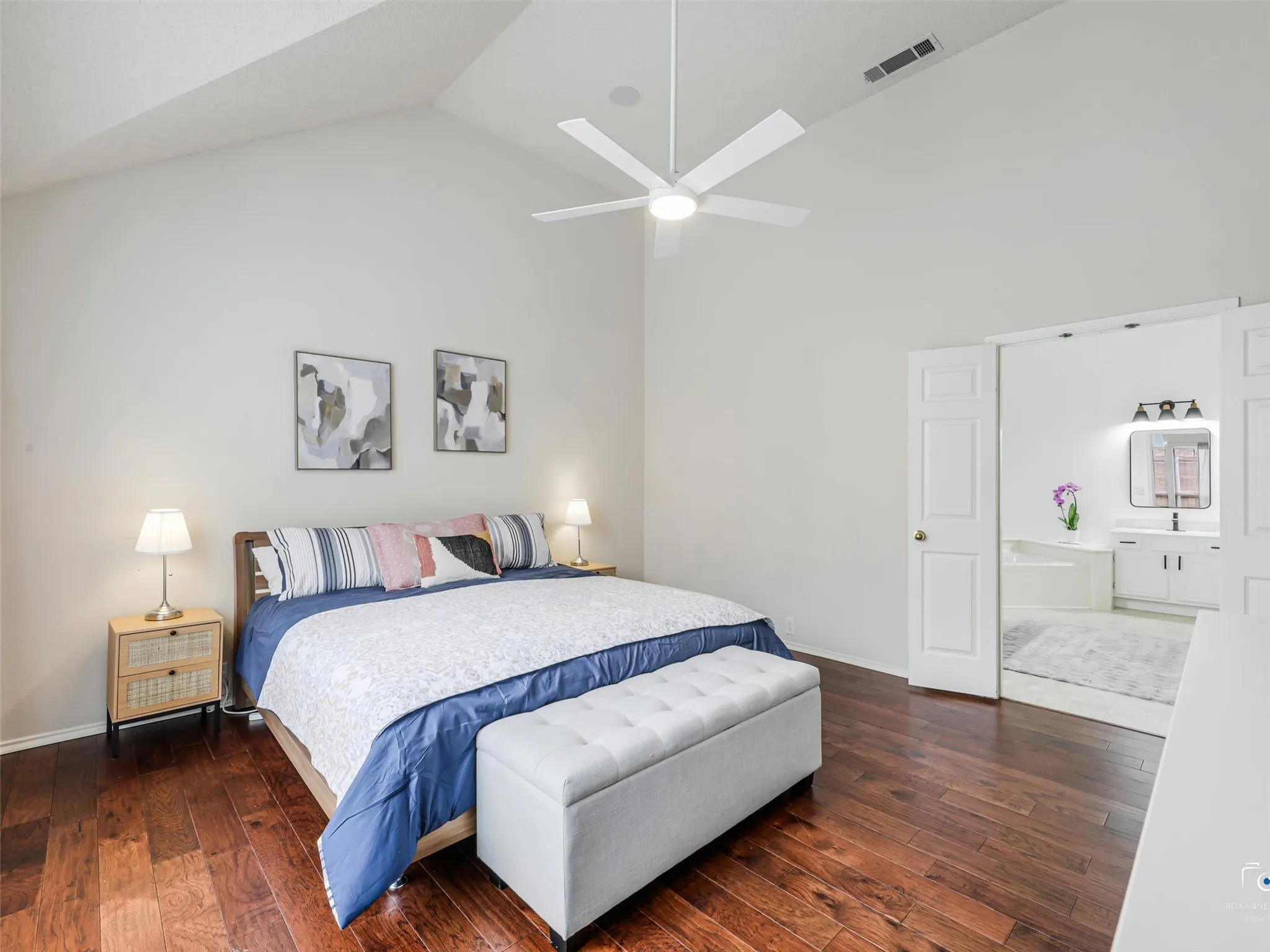 This primary bedroom offers rich wood flooring, lots of natural light, plenty of space an high ceilings.