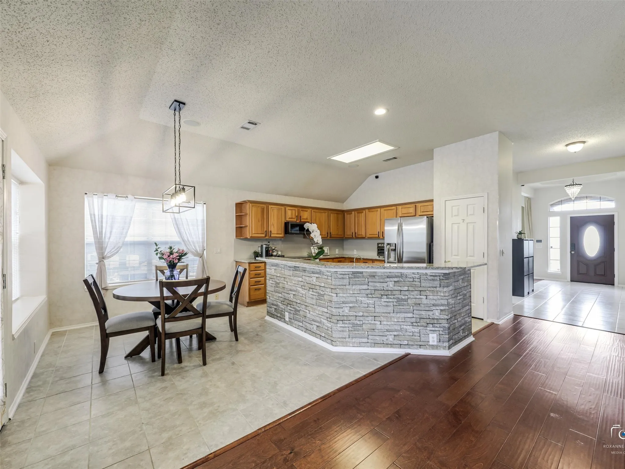 Prepare meals with ease in this spacious kitchen offering extensive counter space, stainless steel appliances, ample storage, and a large center peninsula ideal for casual dining and hosting guests.