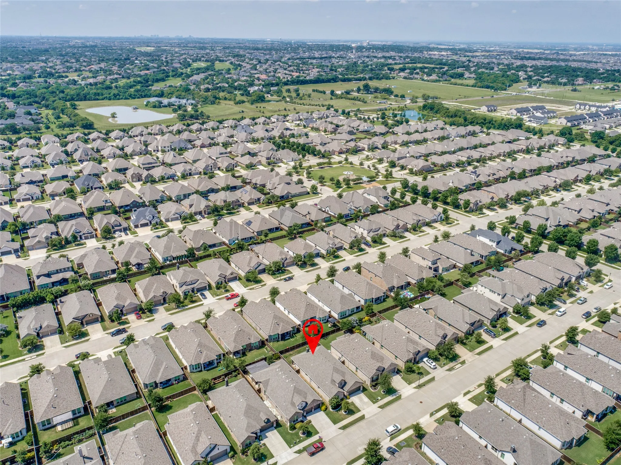 Aerial perspective showcasing a residential neighborhood with uniformly designed homes featuring light-colored roofs and green landscaping