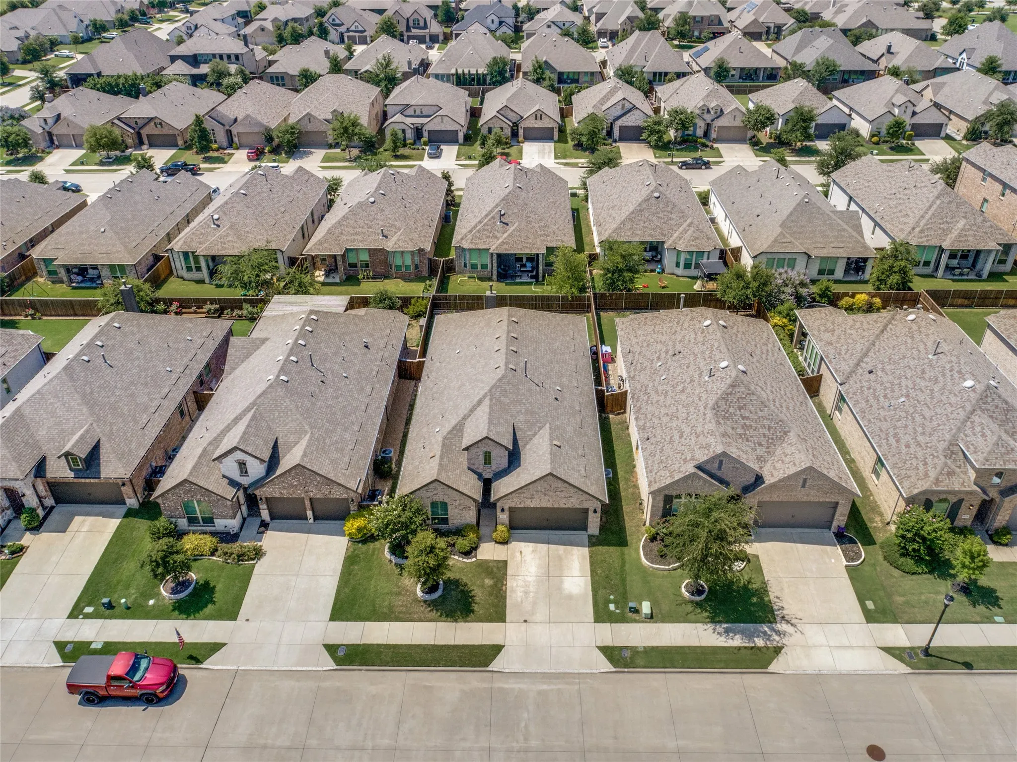 Aerial view of a residential neighborhood featuring uniform, pitched roofs and individual driveways