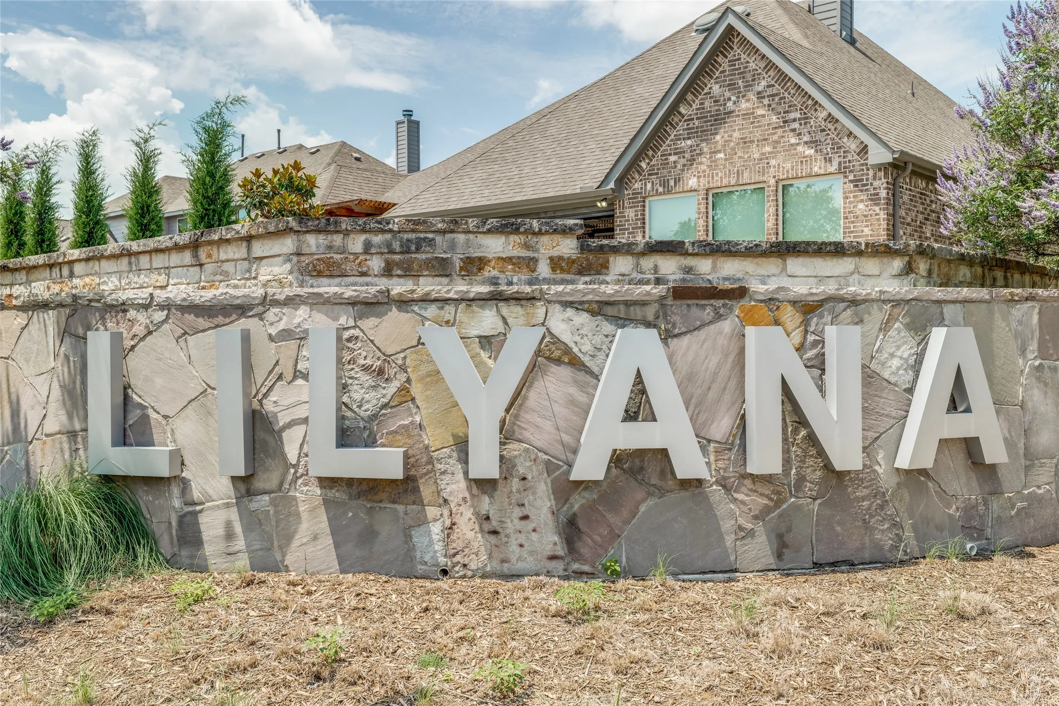 Stone facade entry signage featuring dimensional lettering and brick detailing