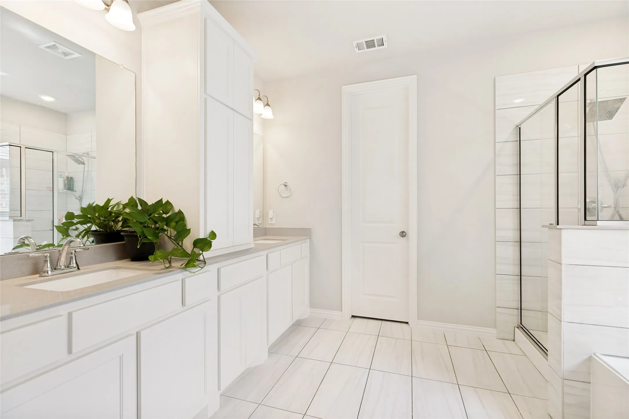 Dual vanity with light-toned countertops and undermount sinks