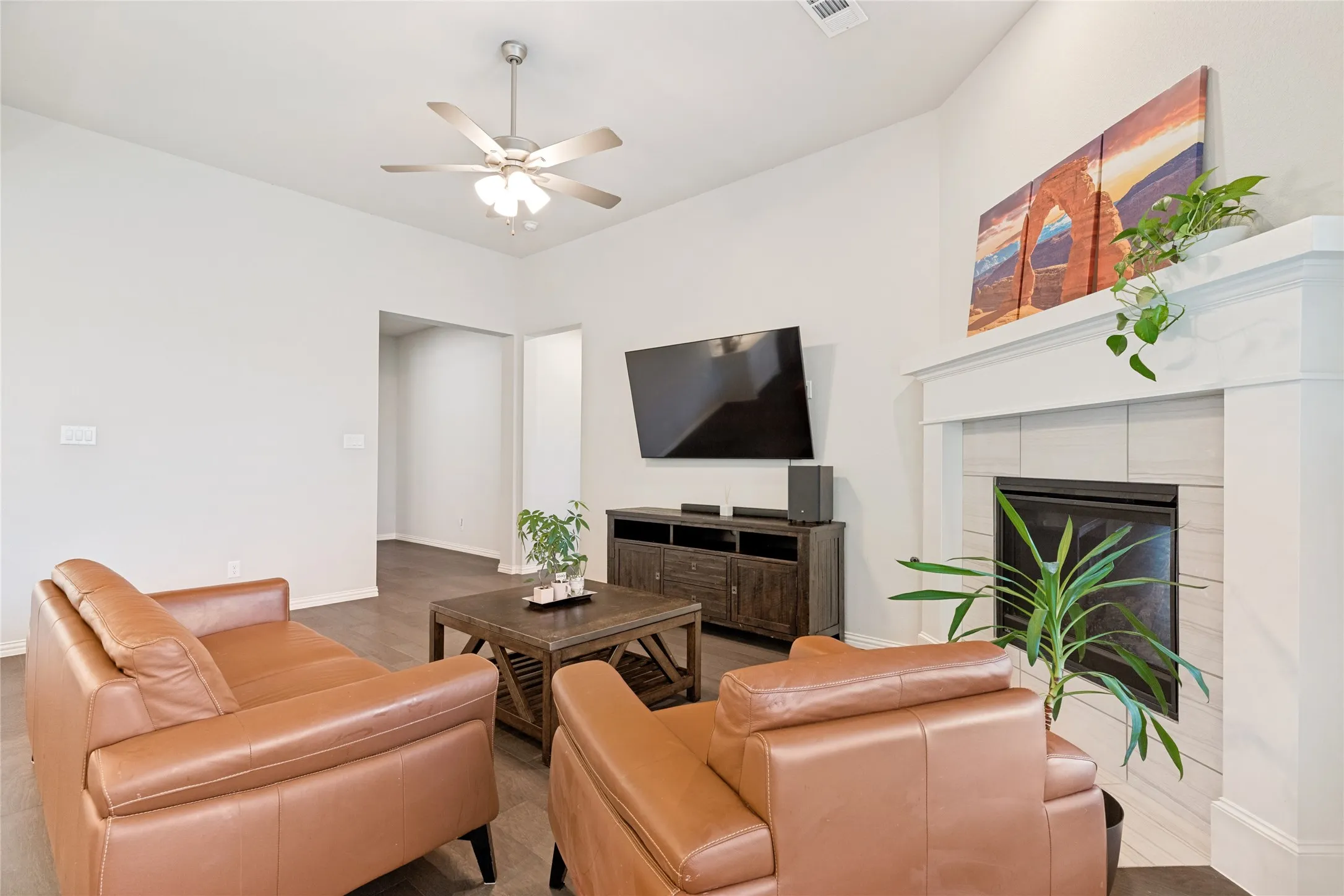 Living room featuring a fireplace with a white mantel, light-toned tile surround, and a dark firebox