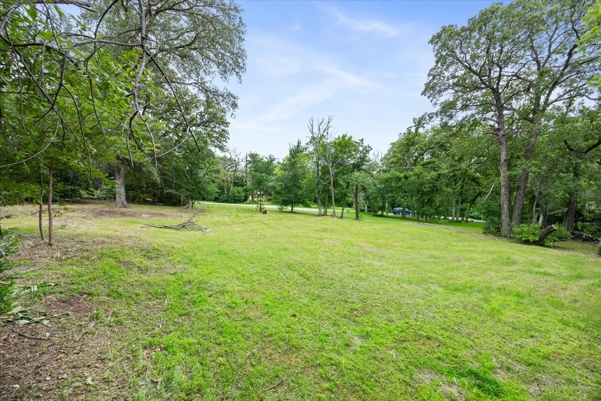Expansive green lawn surrounded by mature trees