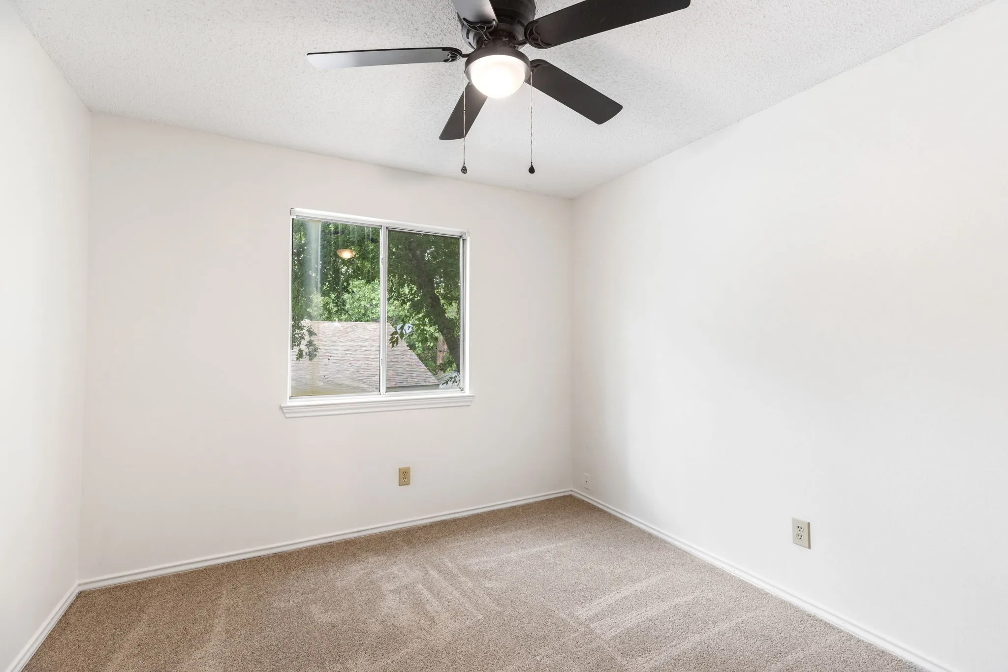 Neutral tone walls with a textured ceiling and ceiling fan