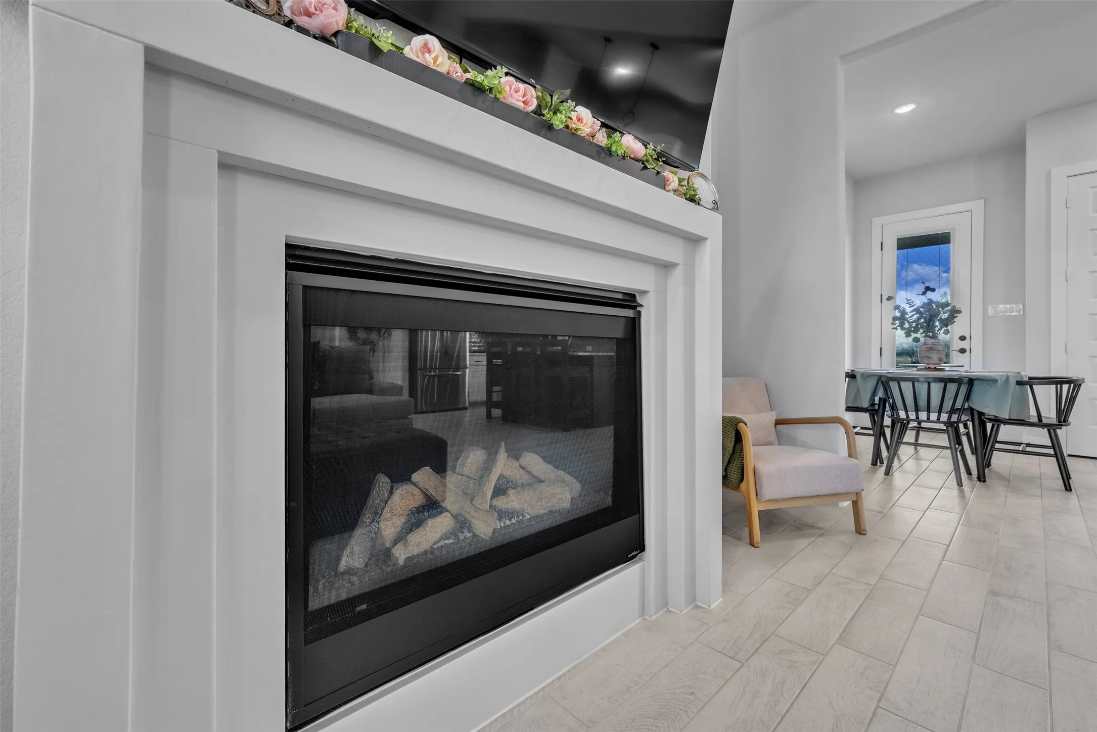 Kitchen featuring an island with seating, pendant lighting, stainless steel appliances, white cabinetry with dark hardware, and light wood-finish flooring