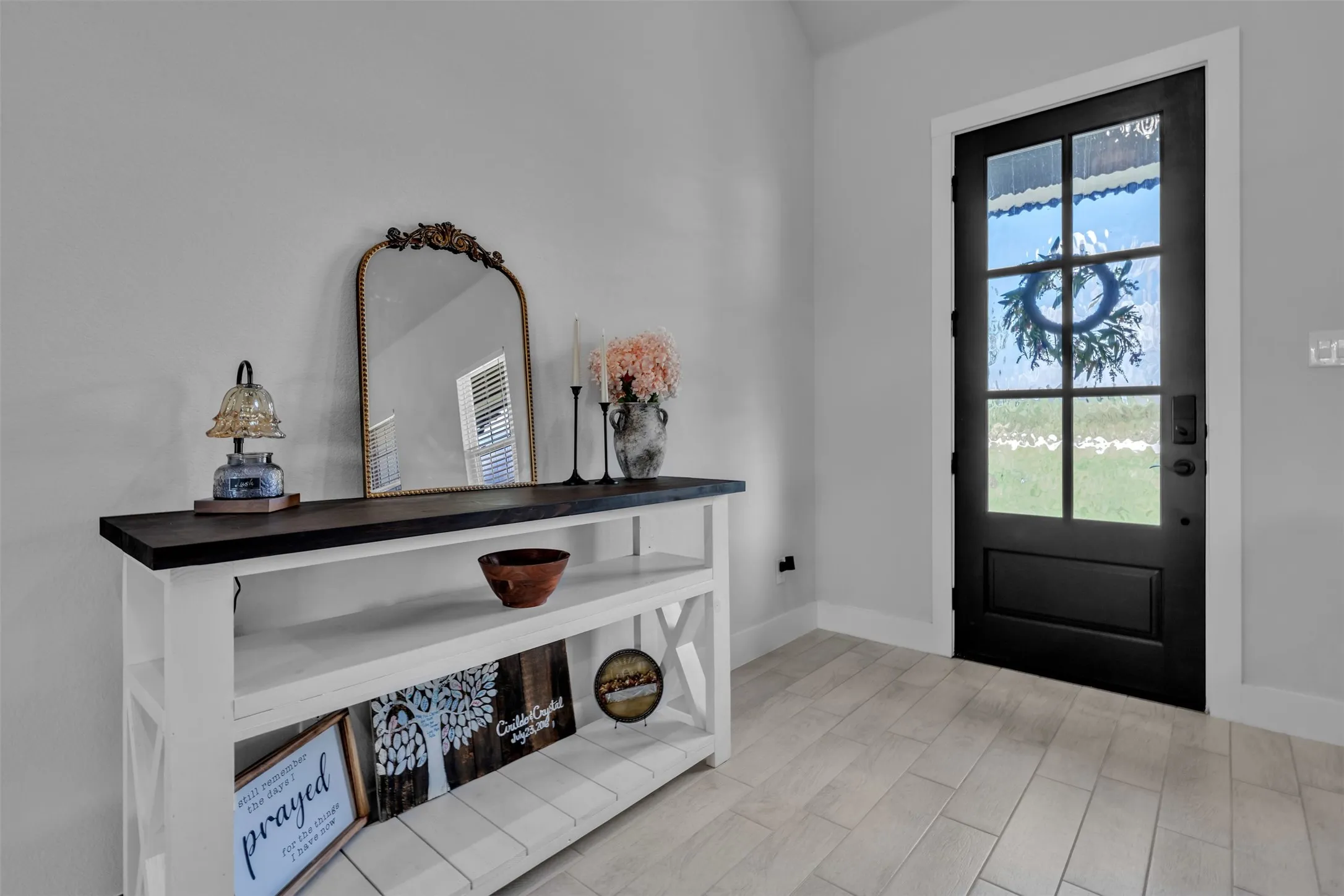 White-trimmed fireplace with a glass-front insert and log media