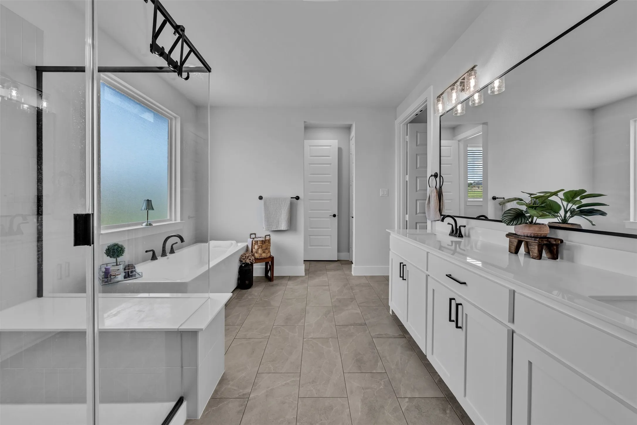 Double vanity with white cabinetry, matte black hardware, and integrated sinks