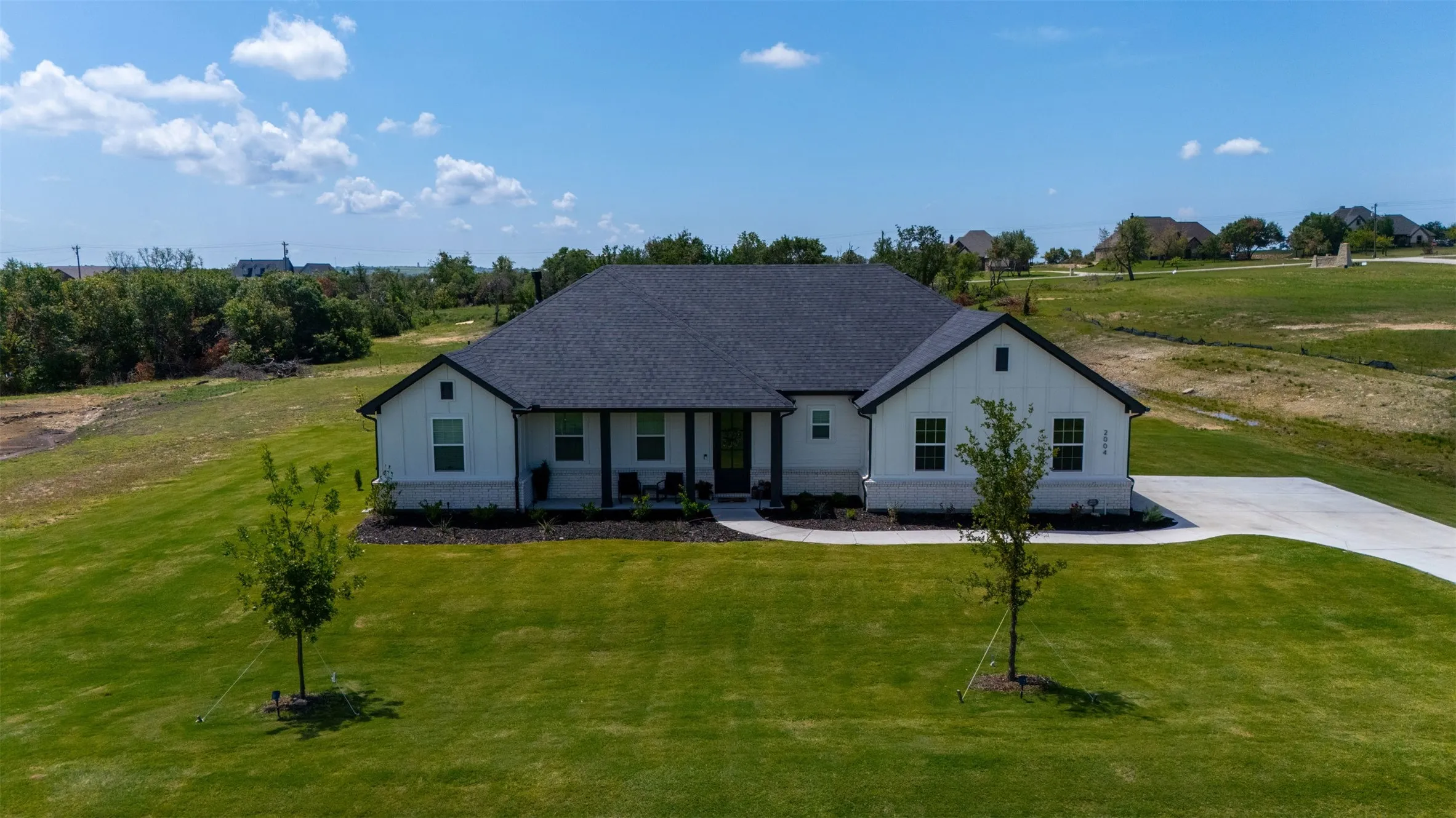 Modern farmhouse exterior with white vertical siding and dark trim