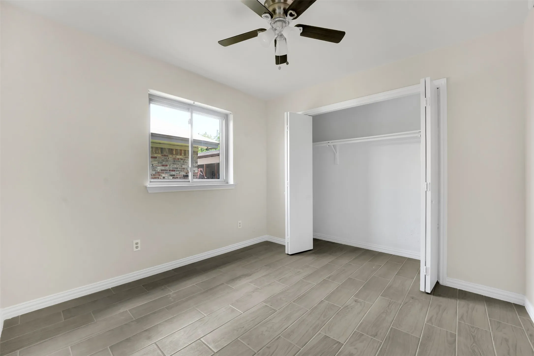 Unfurnished bedroom with wood finish floors, a closet, and a ceiling fan