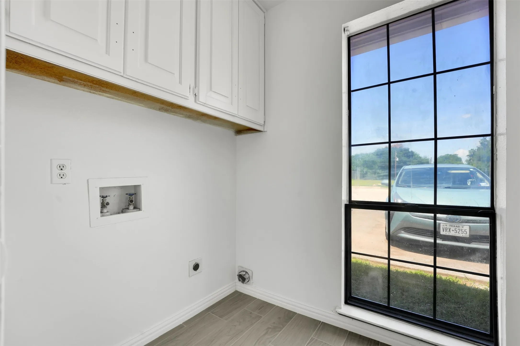 Washroom featuring cabinet space, hookup for an electric dryer, and plenty of natural light