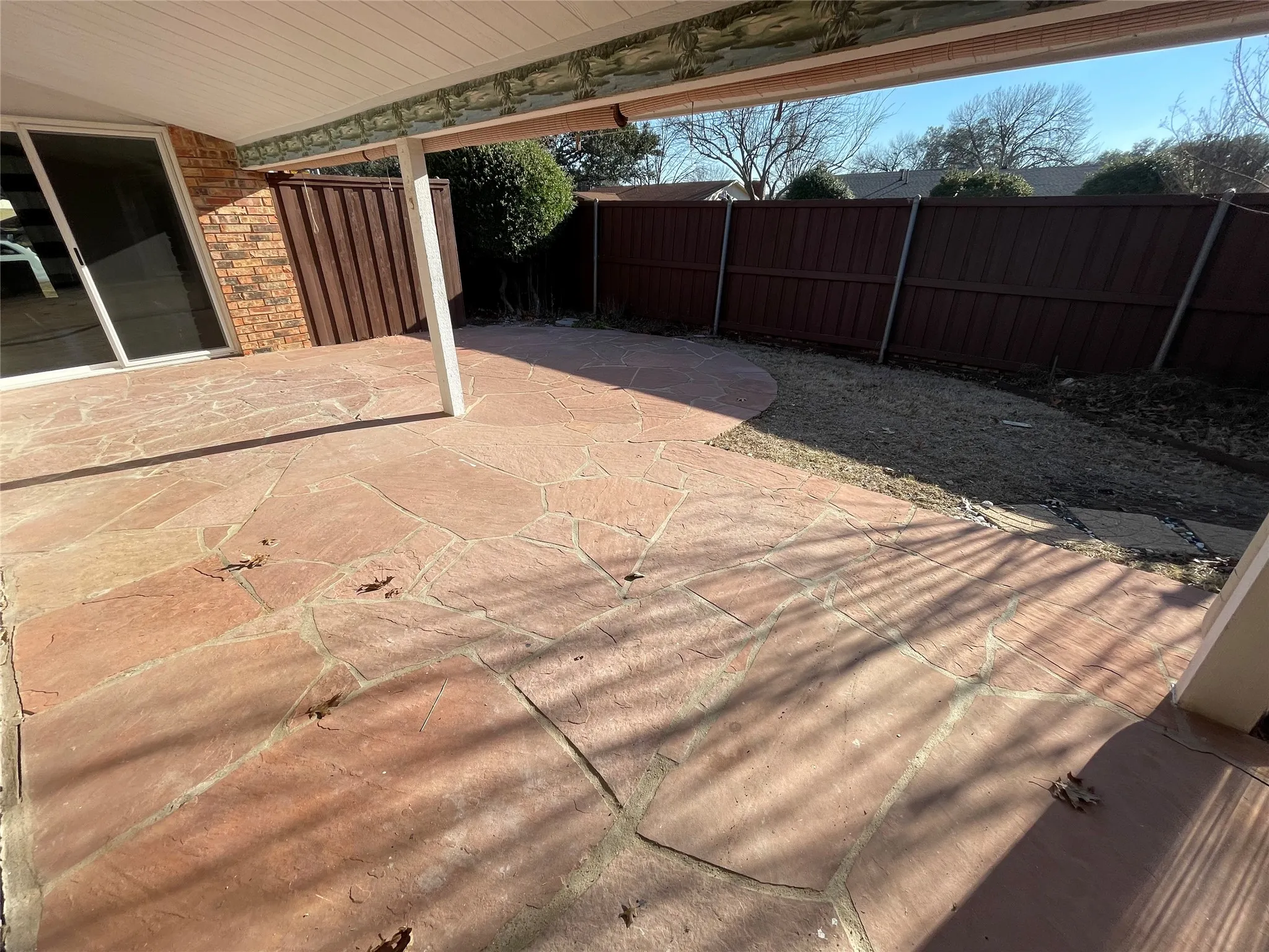 Expansive flagstone patio with a partial overhead covering