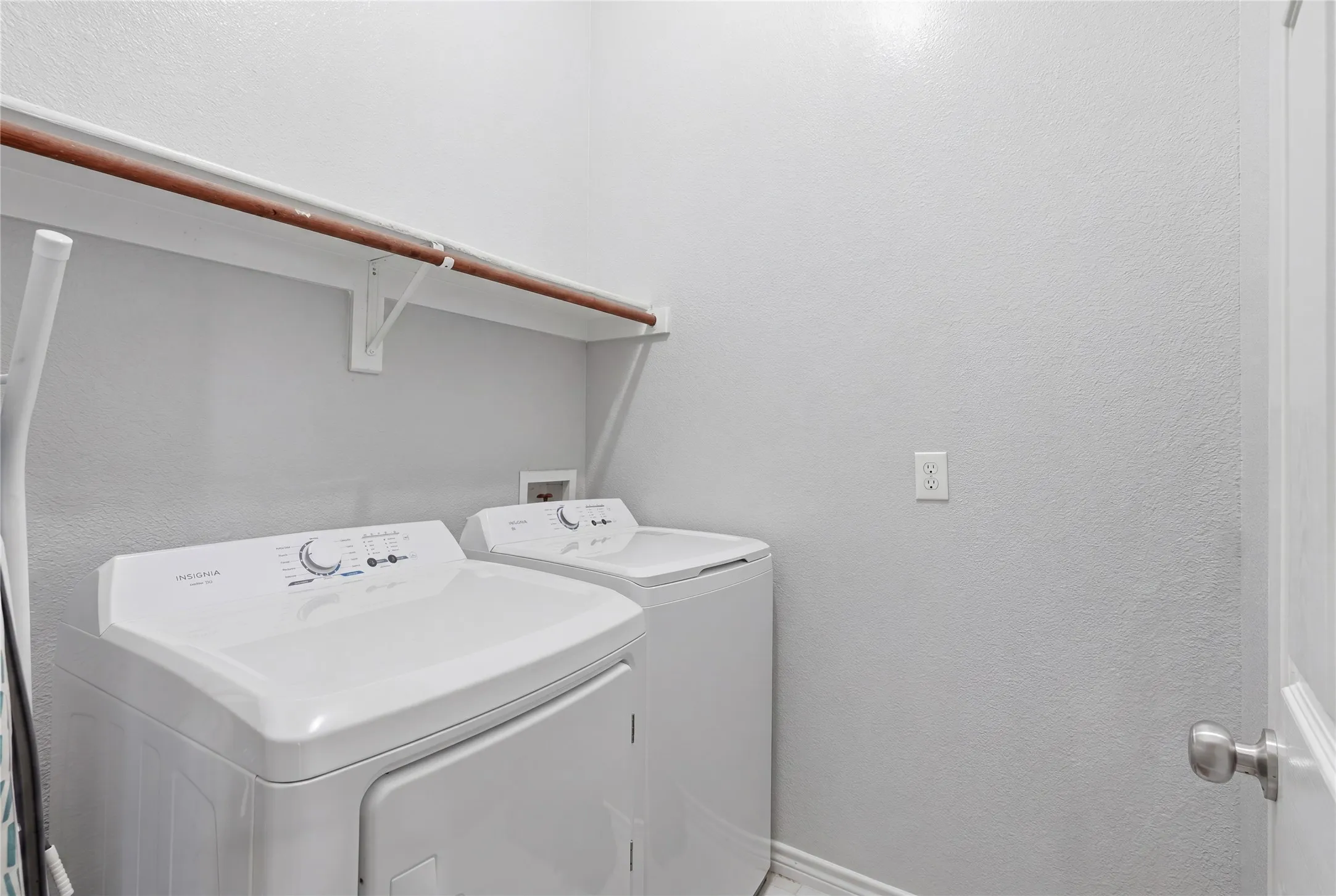 Dedicated laundry area featuring a white wall shelf with a clothing rod