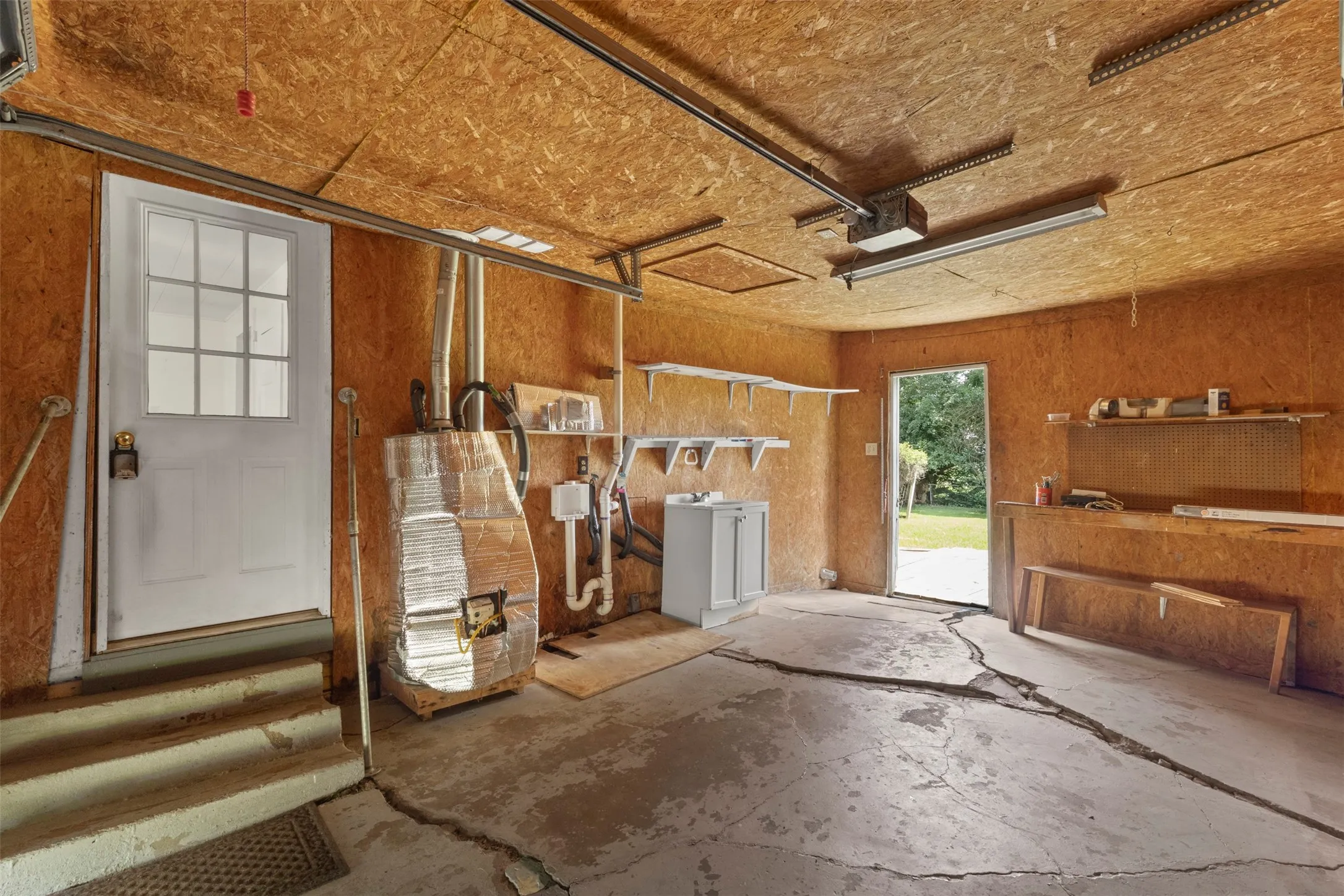 Concrete floor garage with exposed wood-finish walls and ceiling