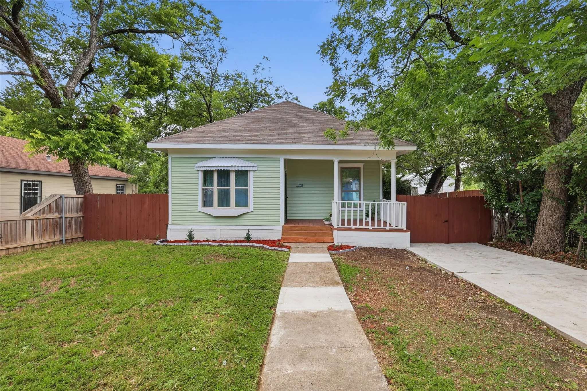 Mint green exterior with white trim, a covered front porch, and a bay window