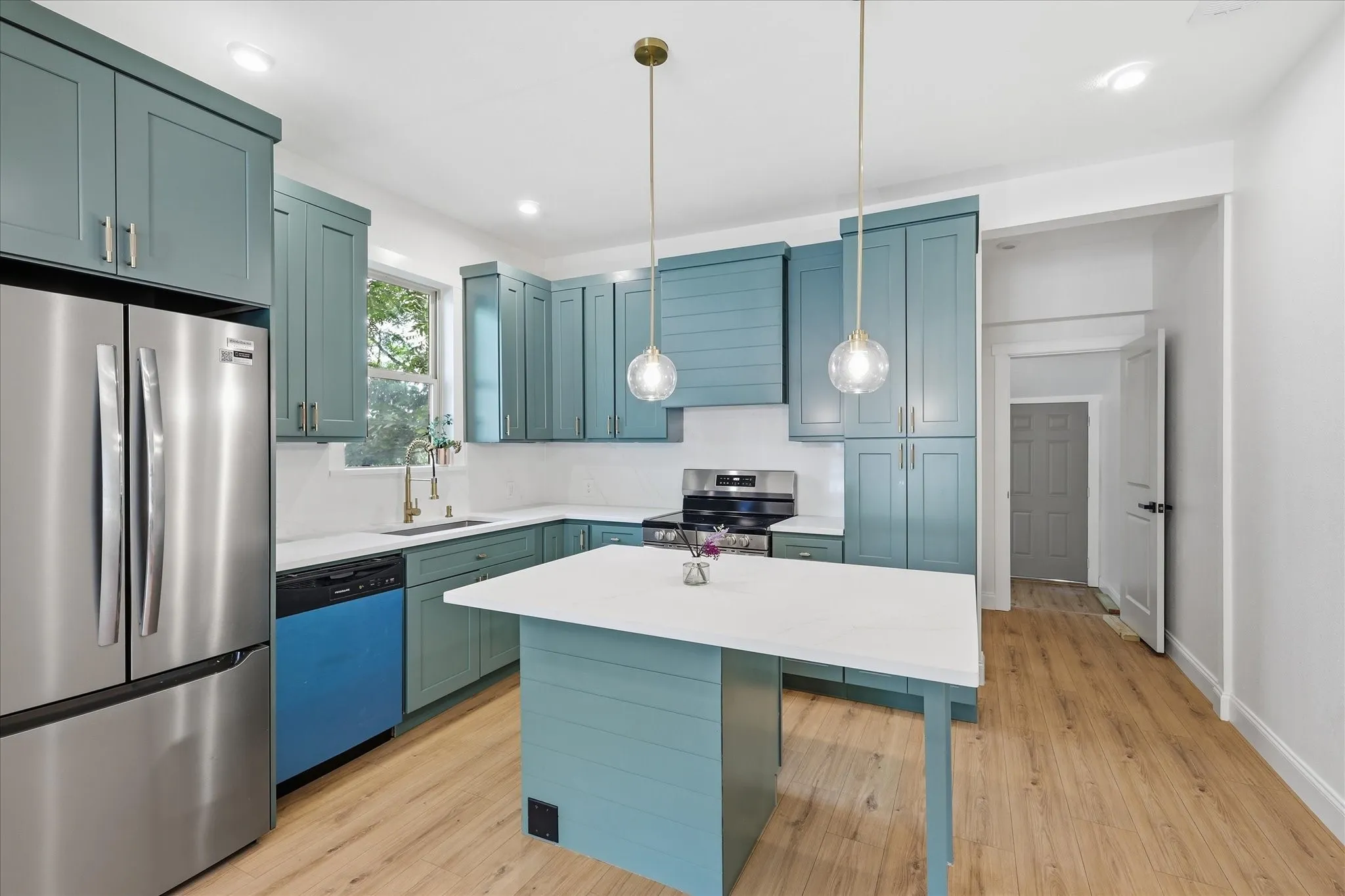 Contemporary kitchen featuring blue-painted cabinetry and a central island with white countertops