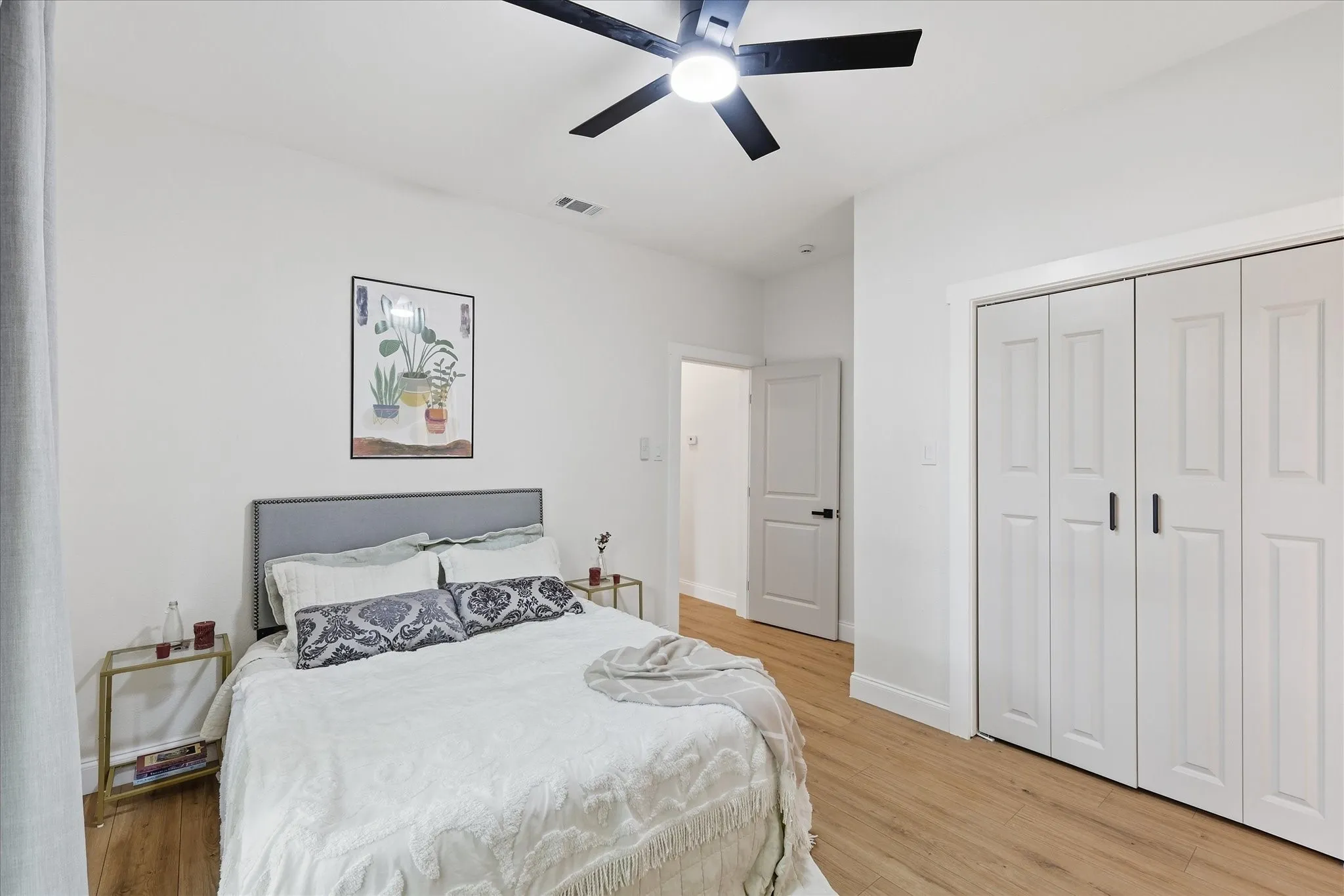 Bedroom featuring wood-finish flooring and a ceiling fan with integrated lighting