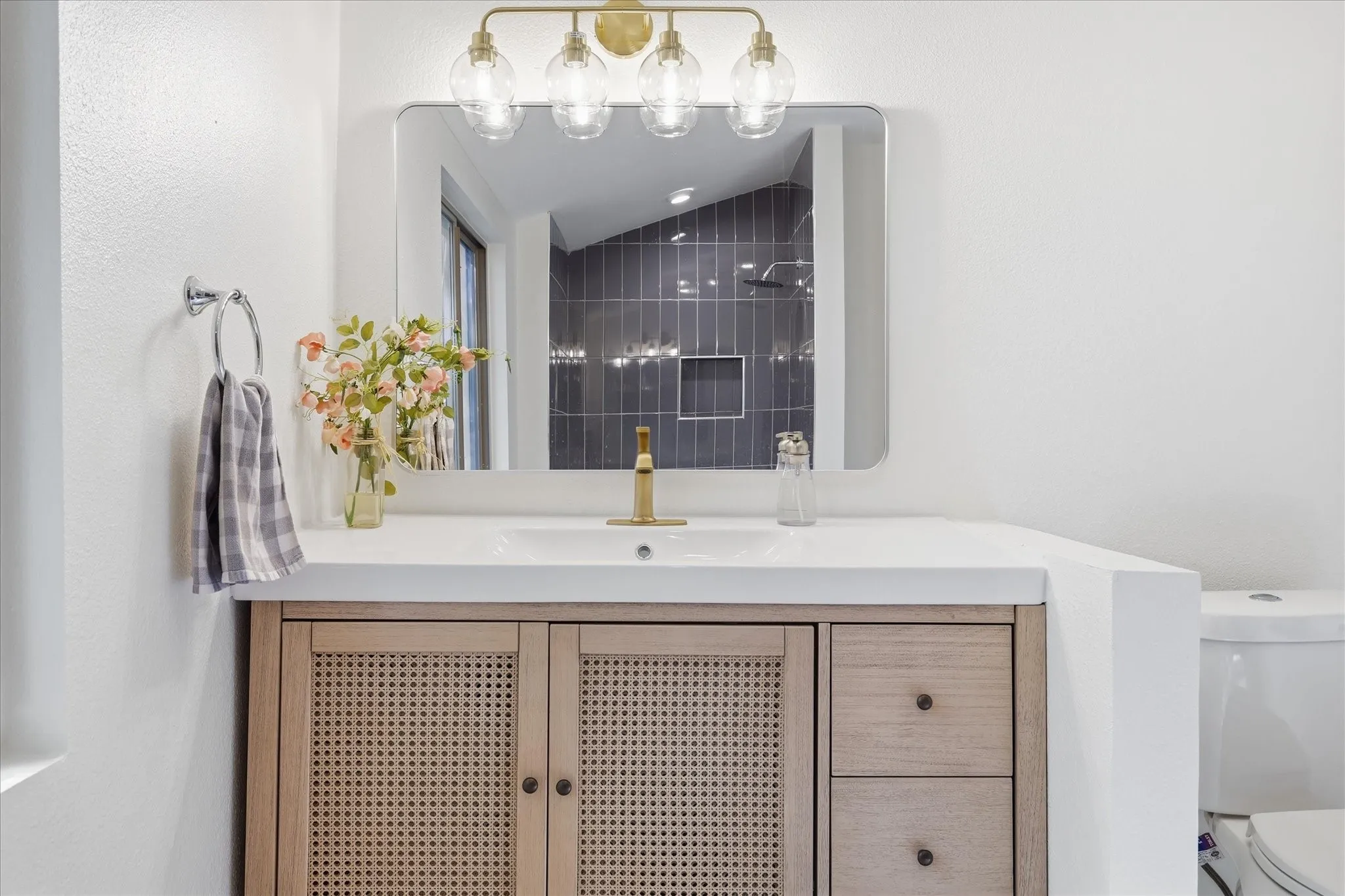 Vanity featuring a light wood-finish with cane detailing, integrated sink, and white countertop