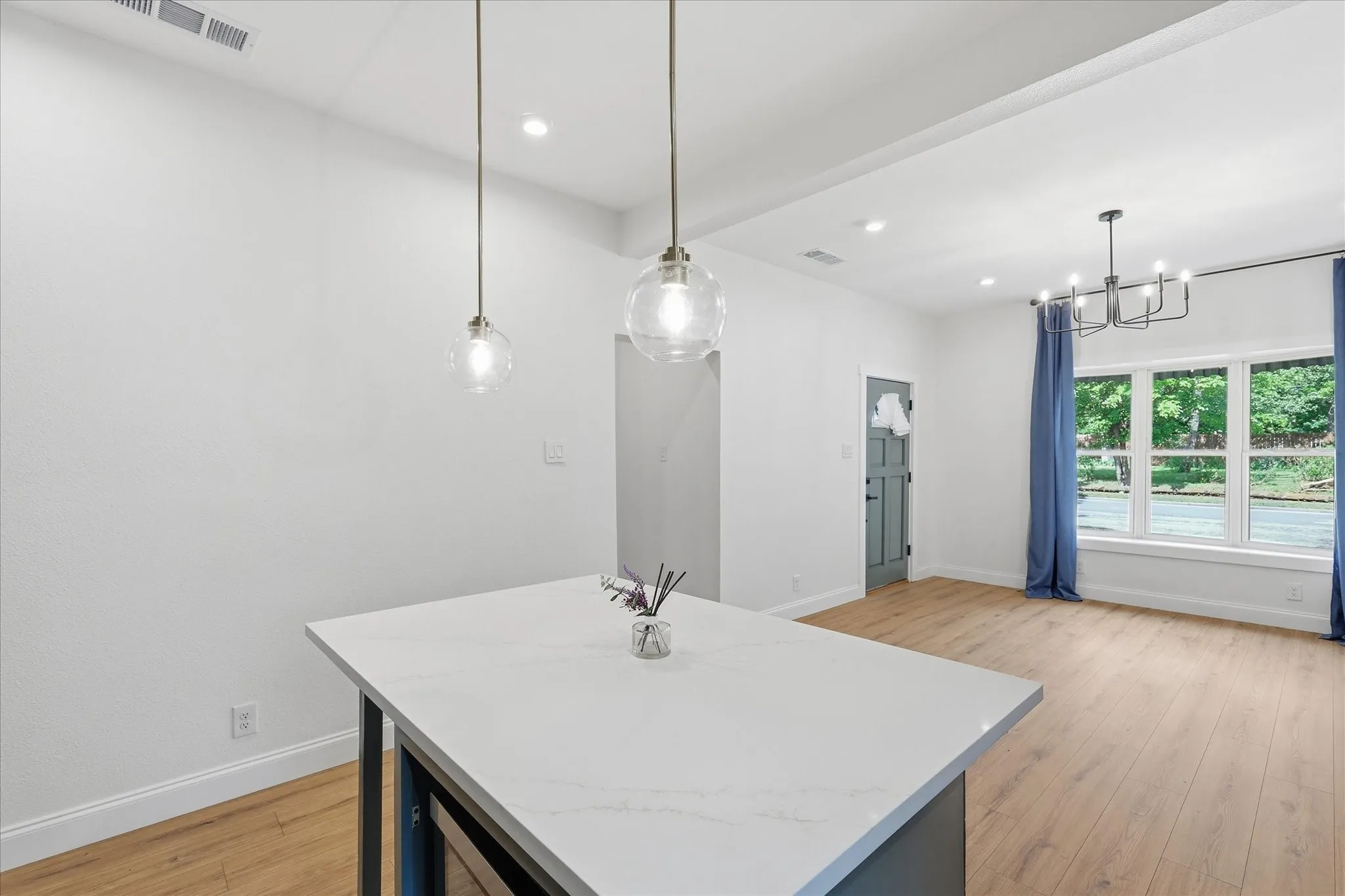 Kitchen island with a white countertop and two suspended pendant lights