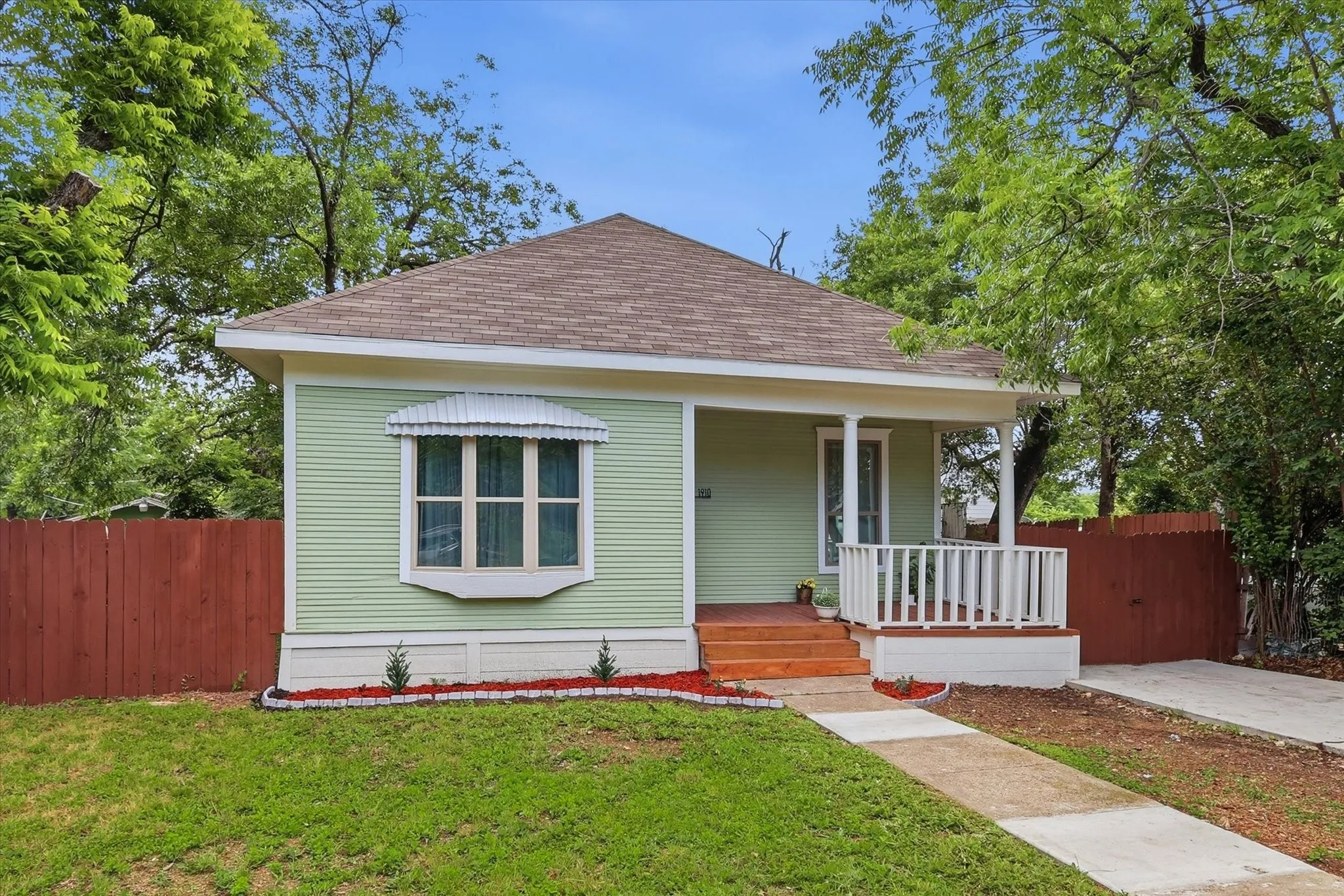 Light green siding exterior with a brown shingle roof
