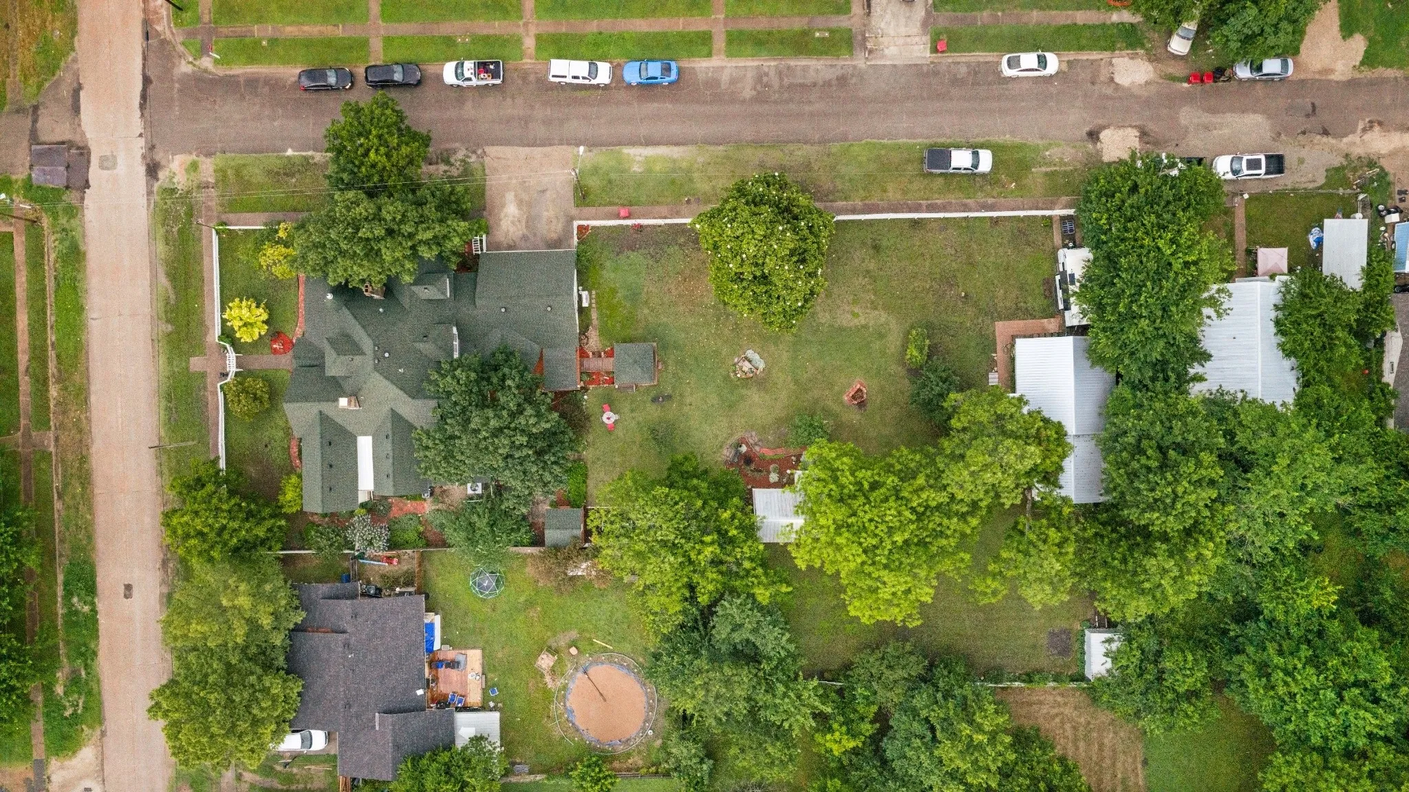 Expansive property featuring two distinct structures, mature trees, and a substantial yard