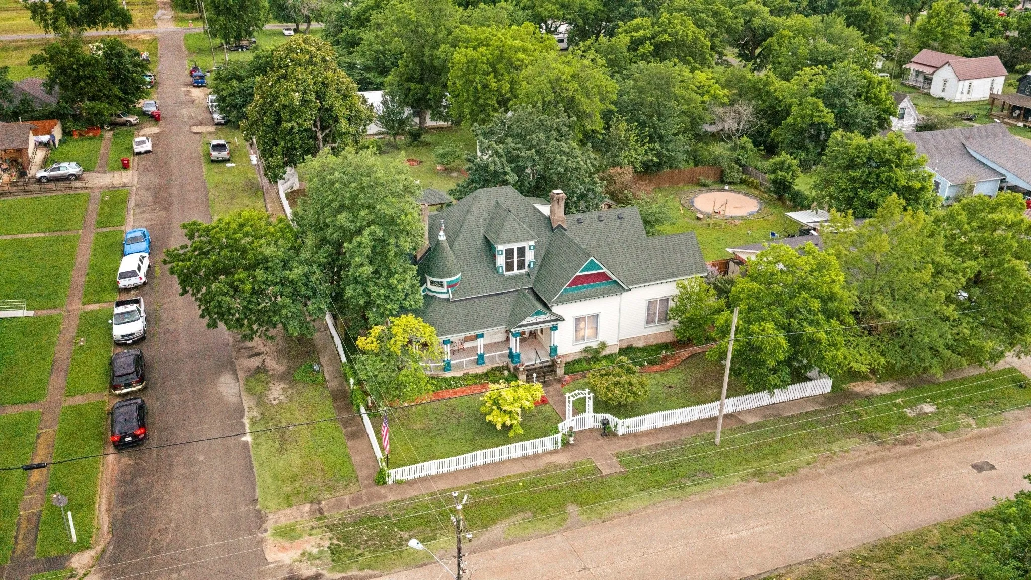 Victorian-style residence featuring a prominent turret and a dark green roof