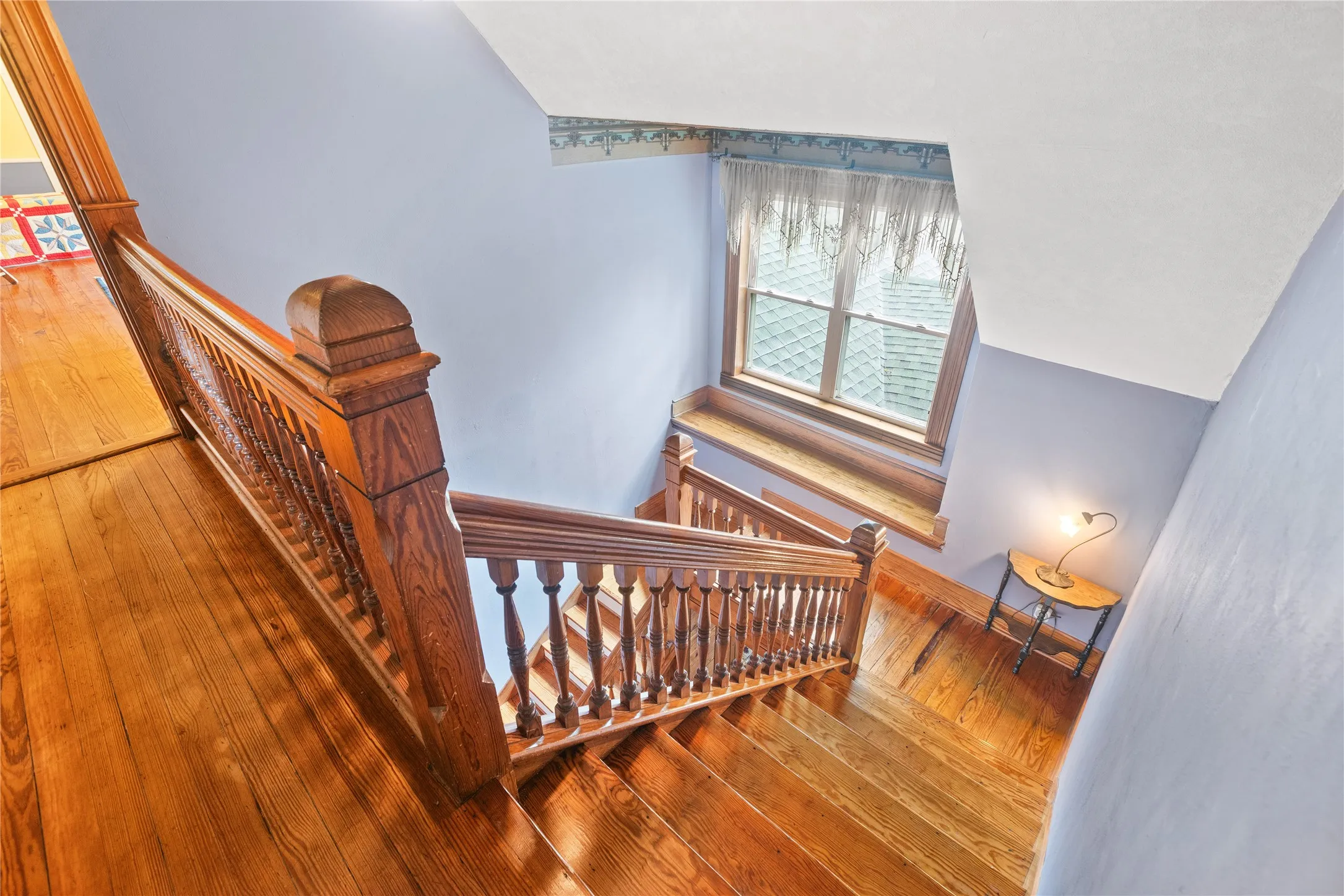 Hardwood staircase with ornate wood balusters, a substantial newel post, and a matching wood handrail
