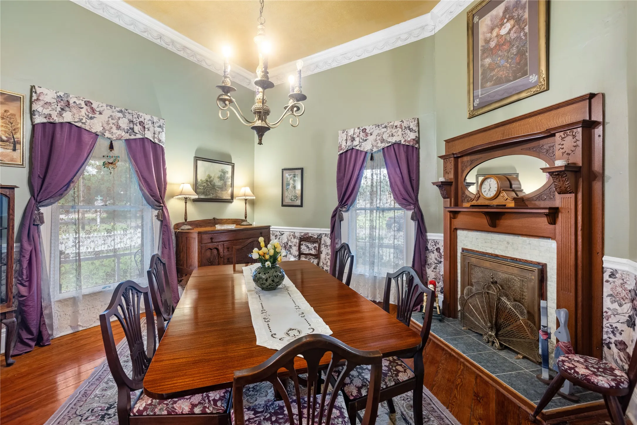 Dining area featuring a prominent wood fireplace with an ornate mantel and integrated mirror