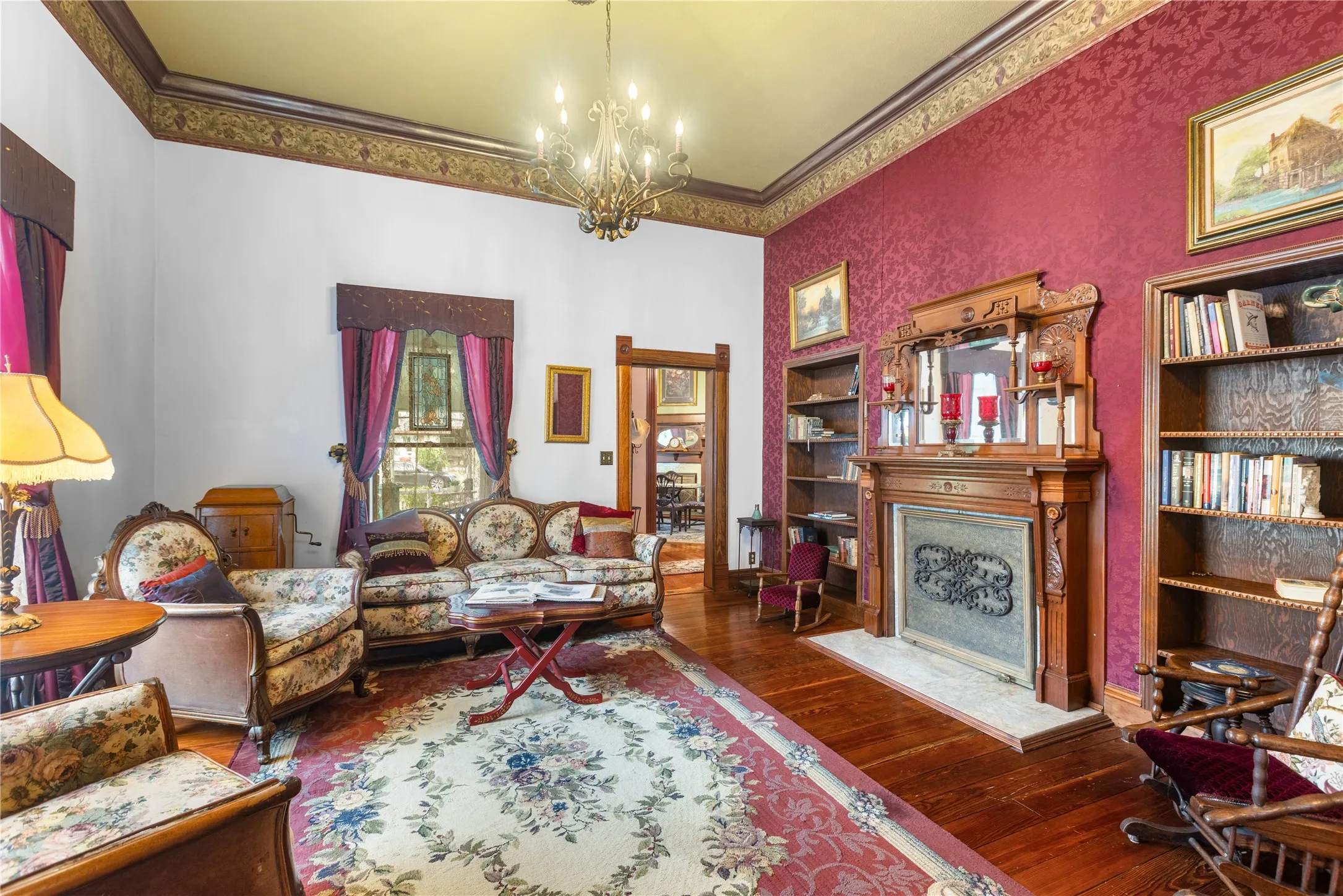 Formal Living area featuring an ornate wood fireplace mantel with an integrated mirror, flanked by built-in wooden bookshelves