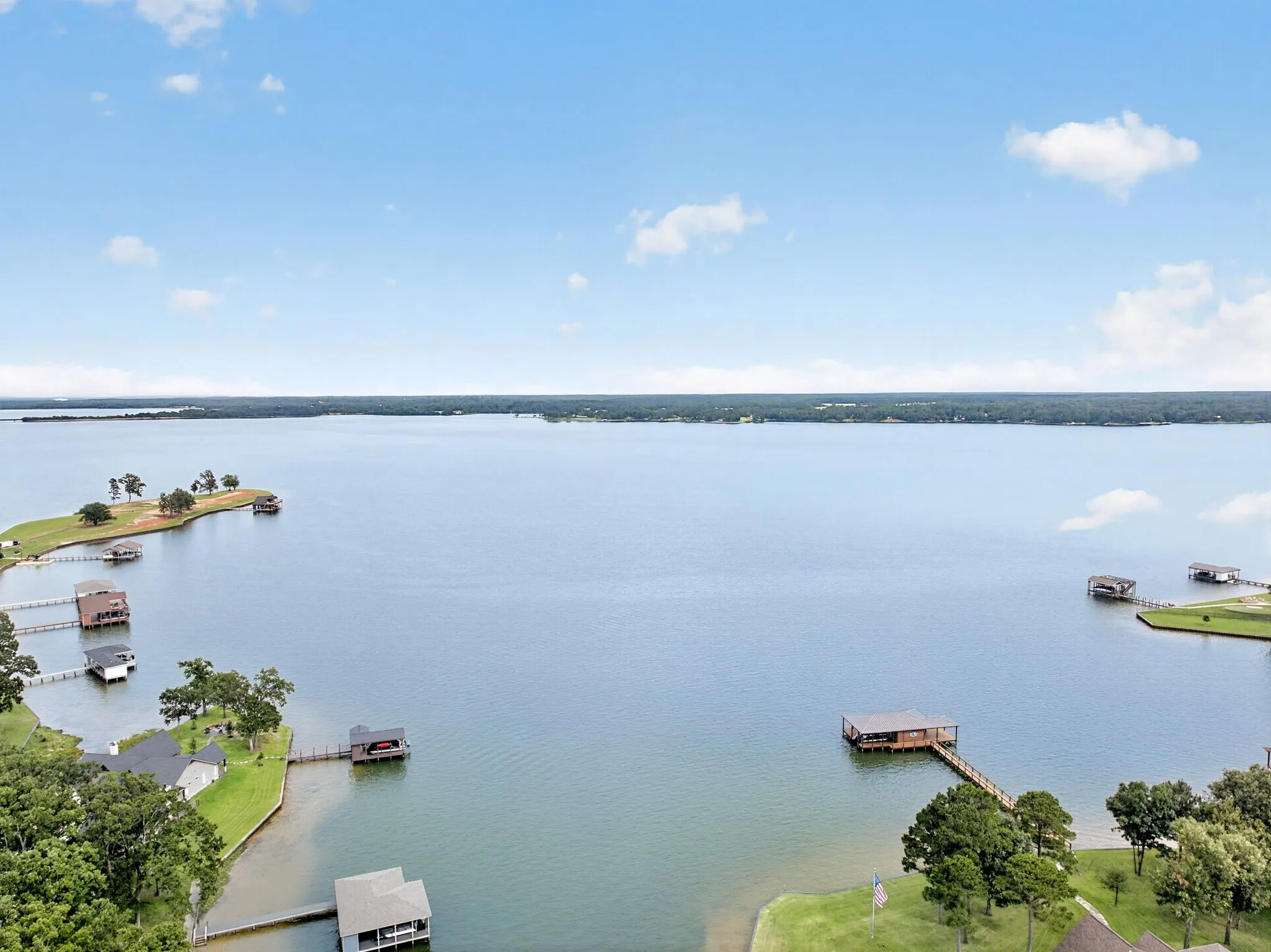 Expansive waterfront property featuring multiple boat houses with covered slips