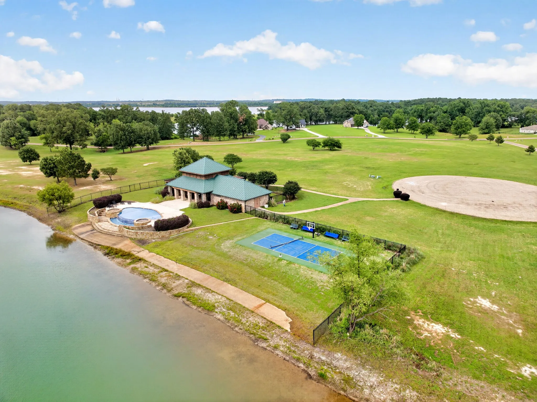 Community amenity center featuring a resort-style swimming pool, spa, and tennis court