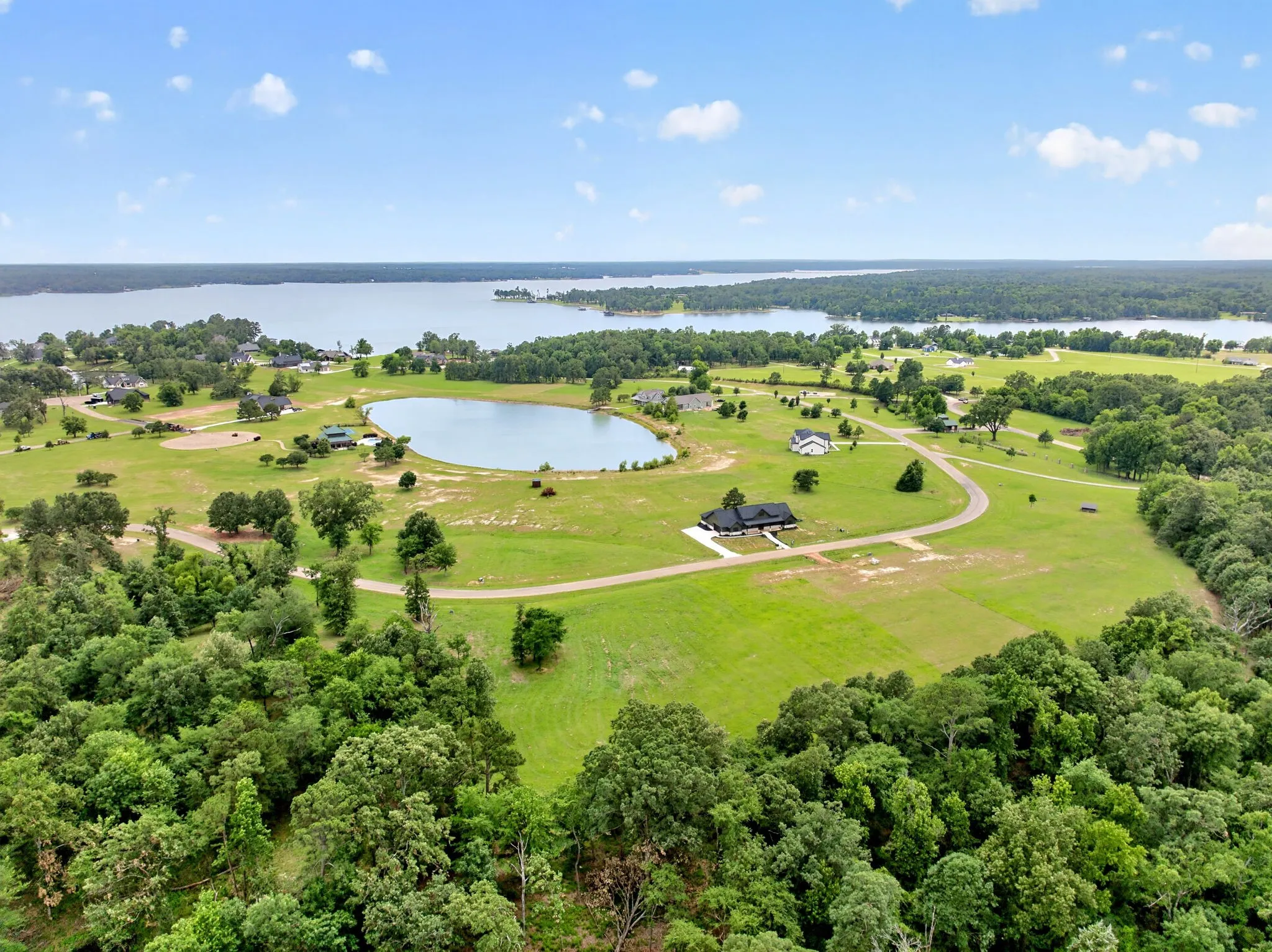 Expansive property featuring a private pond, paved driveway, and substantial wooded areas