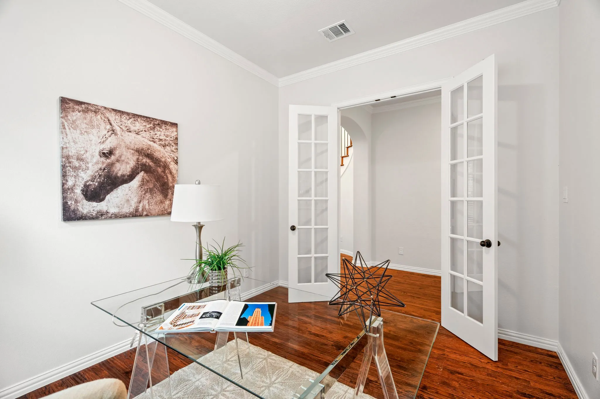 This thoughtfully designed home office features classic French doors, creating a private yet inviting workspace ideal for remote work, productivity, or quiet reading.