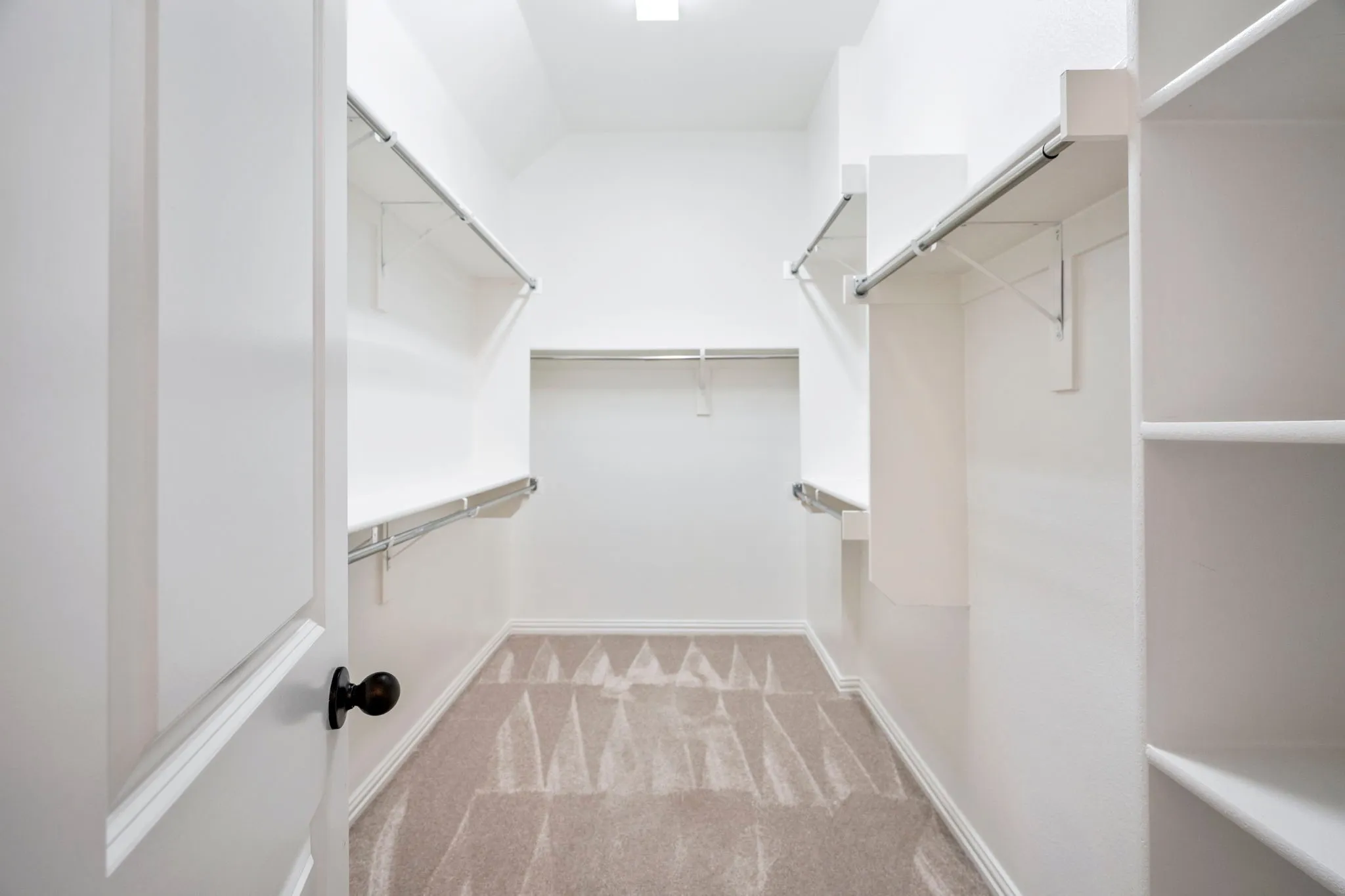 The primary walk-in closet offers generous space and smart organization, creating an easy, functional extension of the primary suite designed to keep everyday living effortlessly organized.