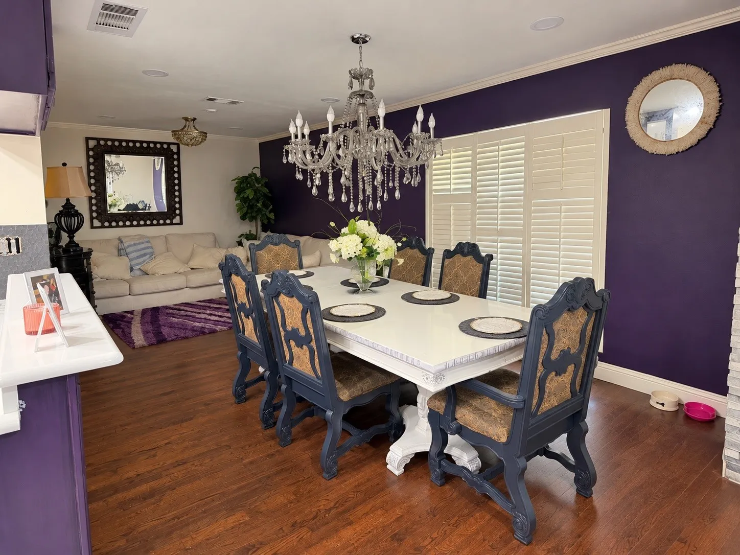 Dining space featuring wood-finish flooring, a crystal chandelier, and plantation shutters