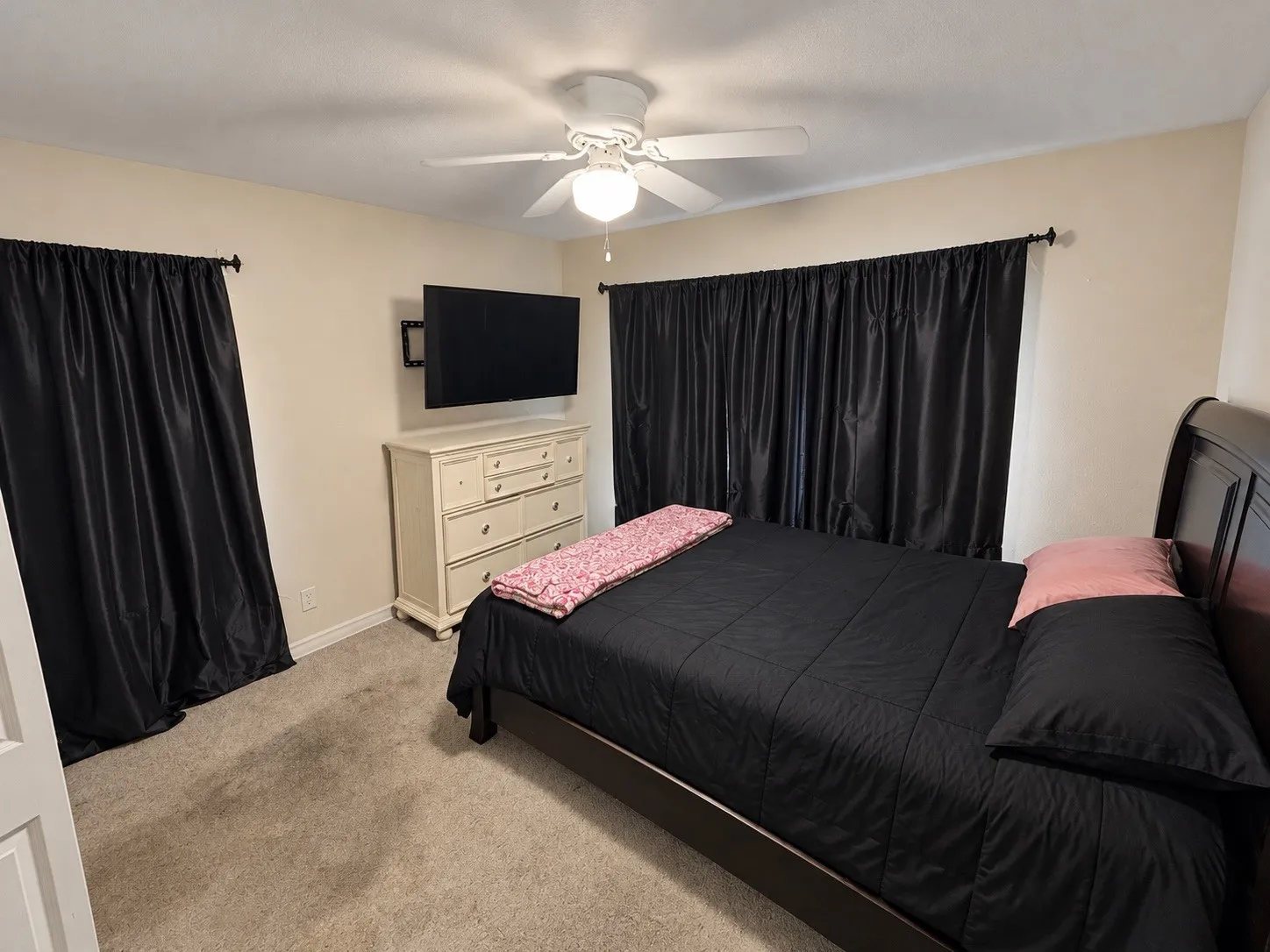 Ceiling fan light fixture, wall-mounted television bracket, carpet flooring, and window treatments