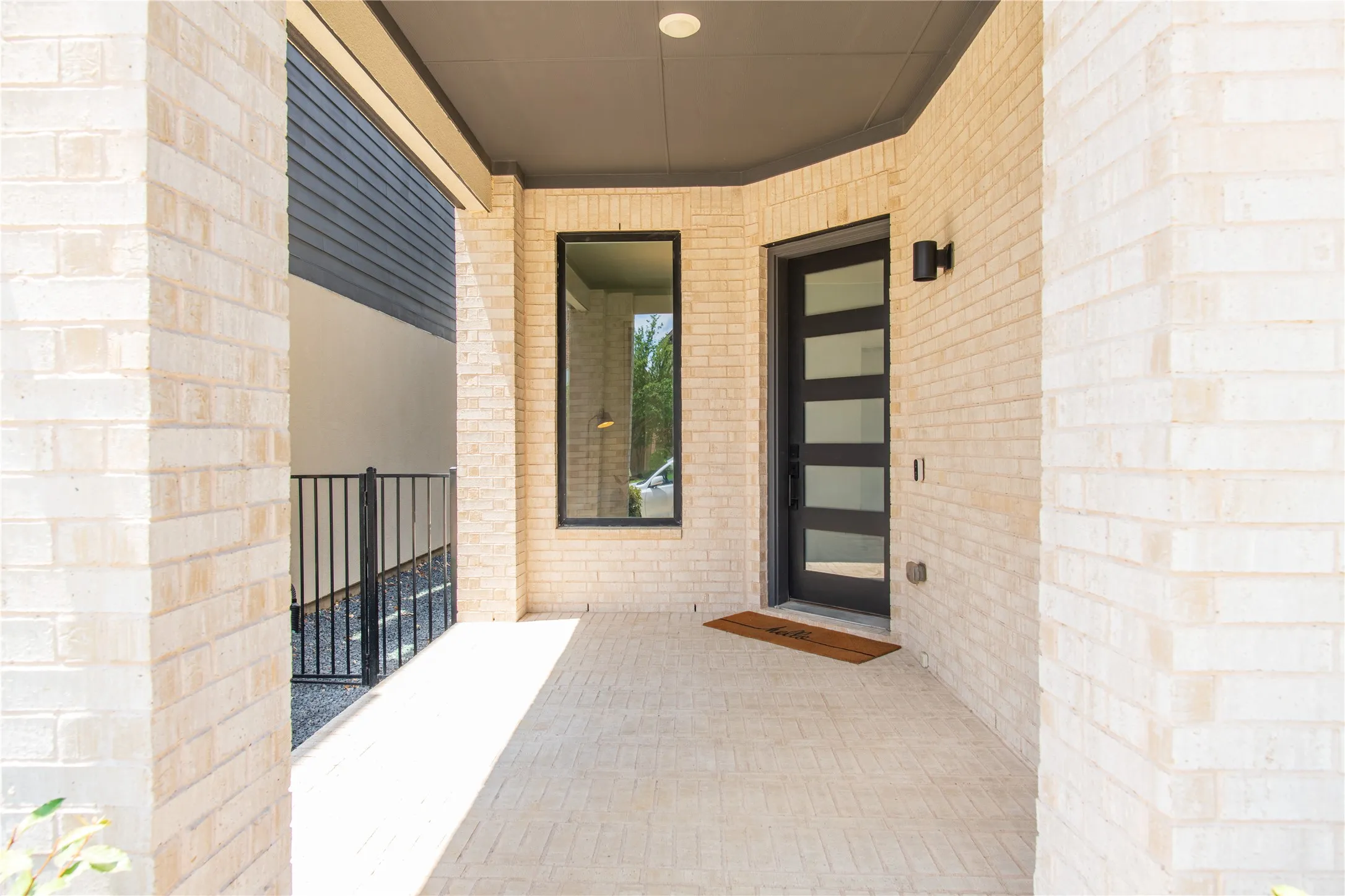 Covered front entry featuring light brick facade