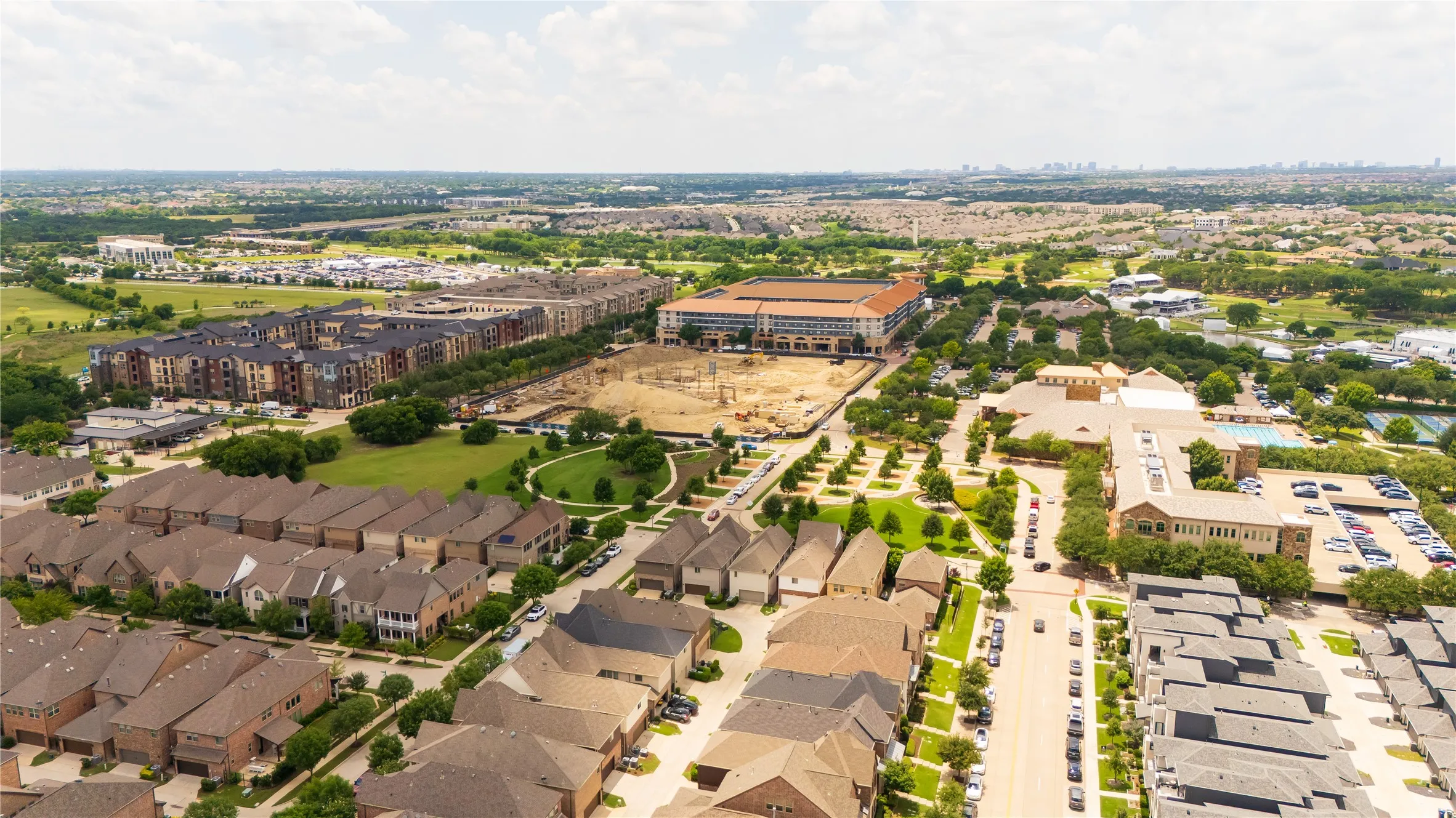 Expansive aerial perspective showcasing a residential neighborhood with diverse architectural styles, including multi-story townhomes and single-family residences