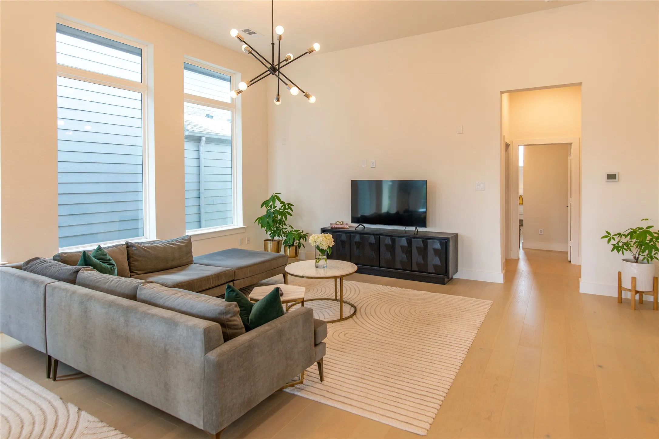 Bright living space featuring tall windows and wood-finish flooring