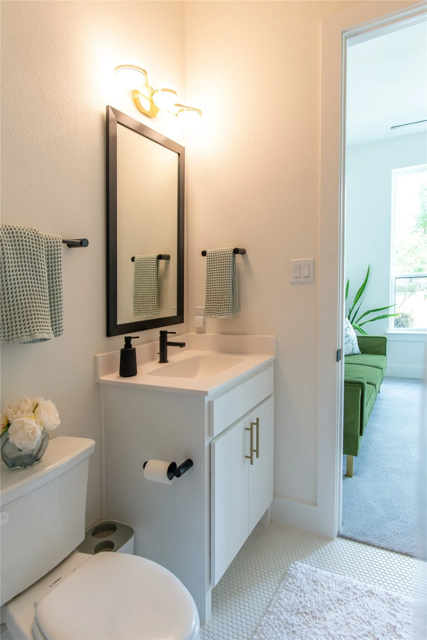 Bathroom featuring a single vanity with white cabinetry, a rectangular undermount sink, and a matte black faucet