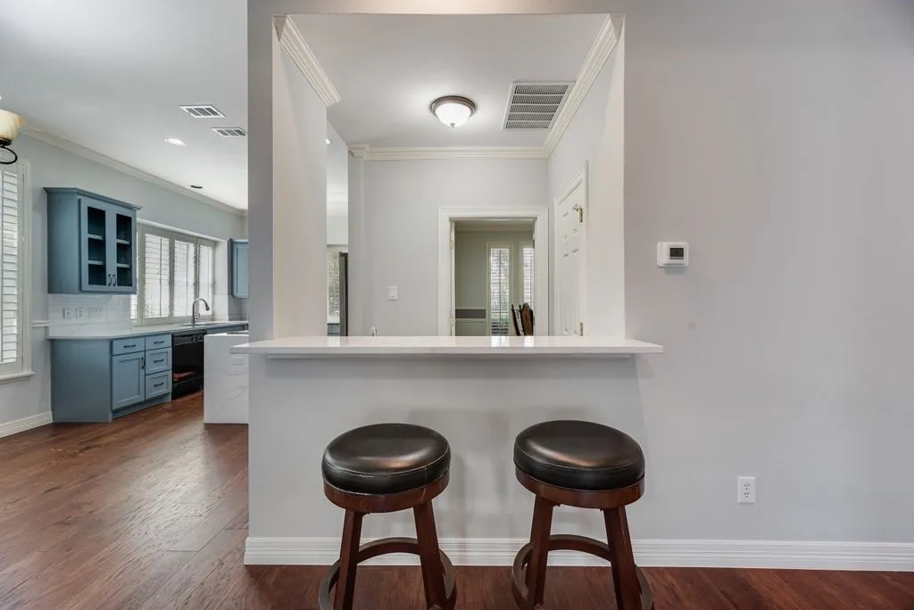 Kitchen pass-through with white countertop and crown molding